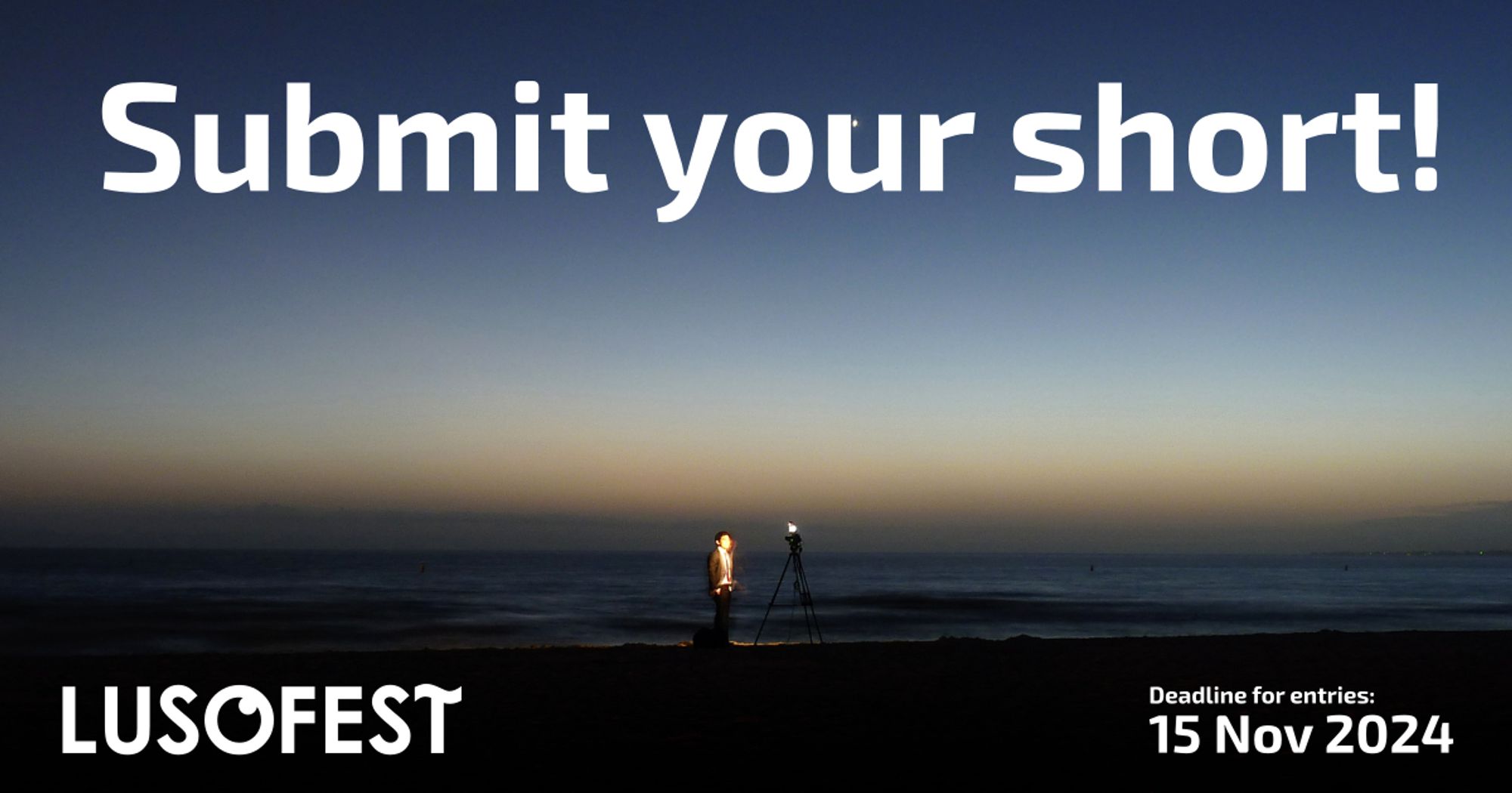 Ein Mann filmt sich selbst mit einem Stativ in der Dämmerung am Strand. Am Himmel steht der Aufruf "Submit your short!" unten steht ein Lusofest-Logo und der Einsendeschluss am 15. November 2024.