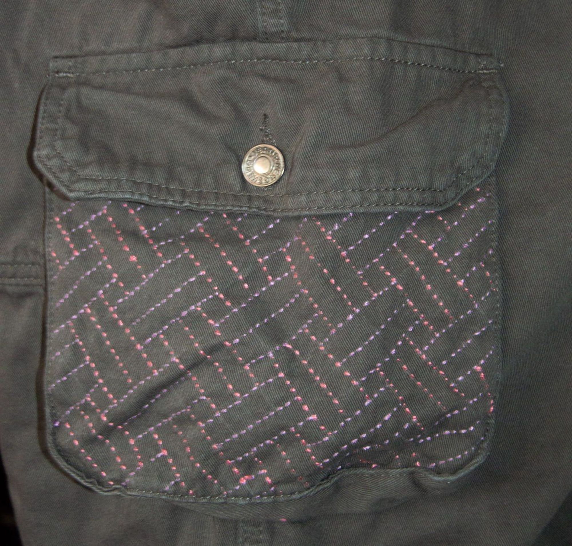 A detail of an embroidery on a overall inspired by the Hirai-Jumon pattern of the Japanese Sashiko style