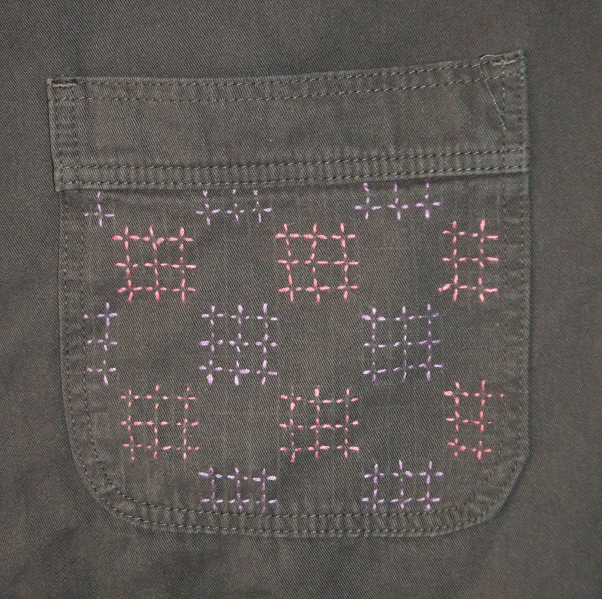 A detail of an embroidery on a overall inspired by the Hishi-Seigaiha pattern of the Japanese Sashiko style