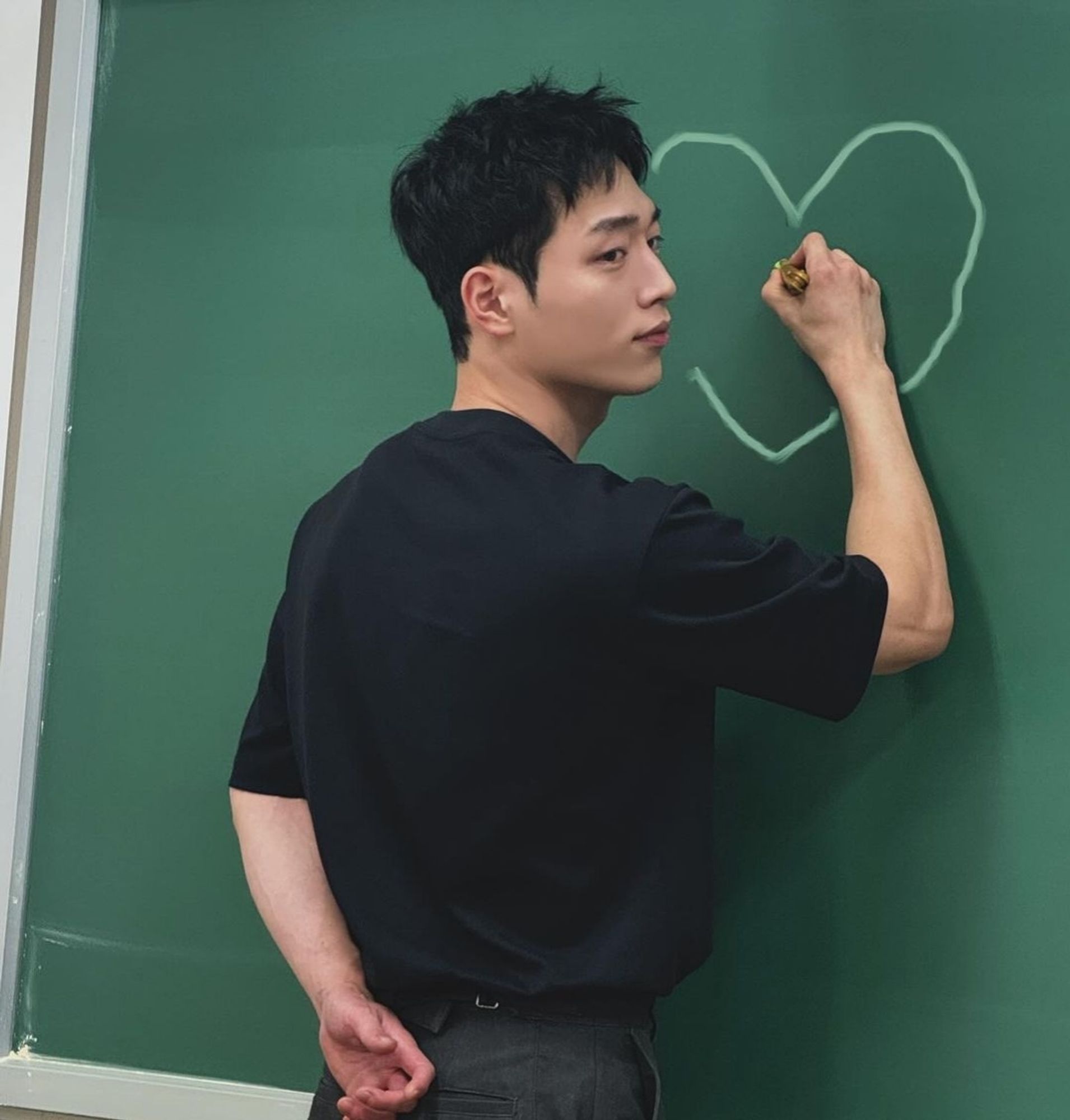 Ator Seo Kang Joon desenhando um coração na lousa