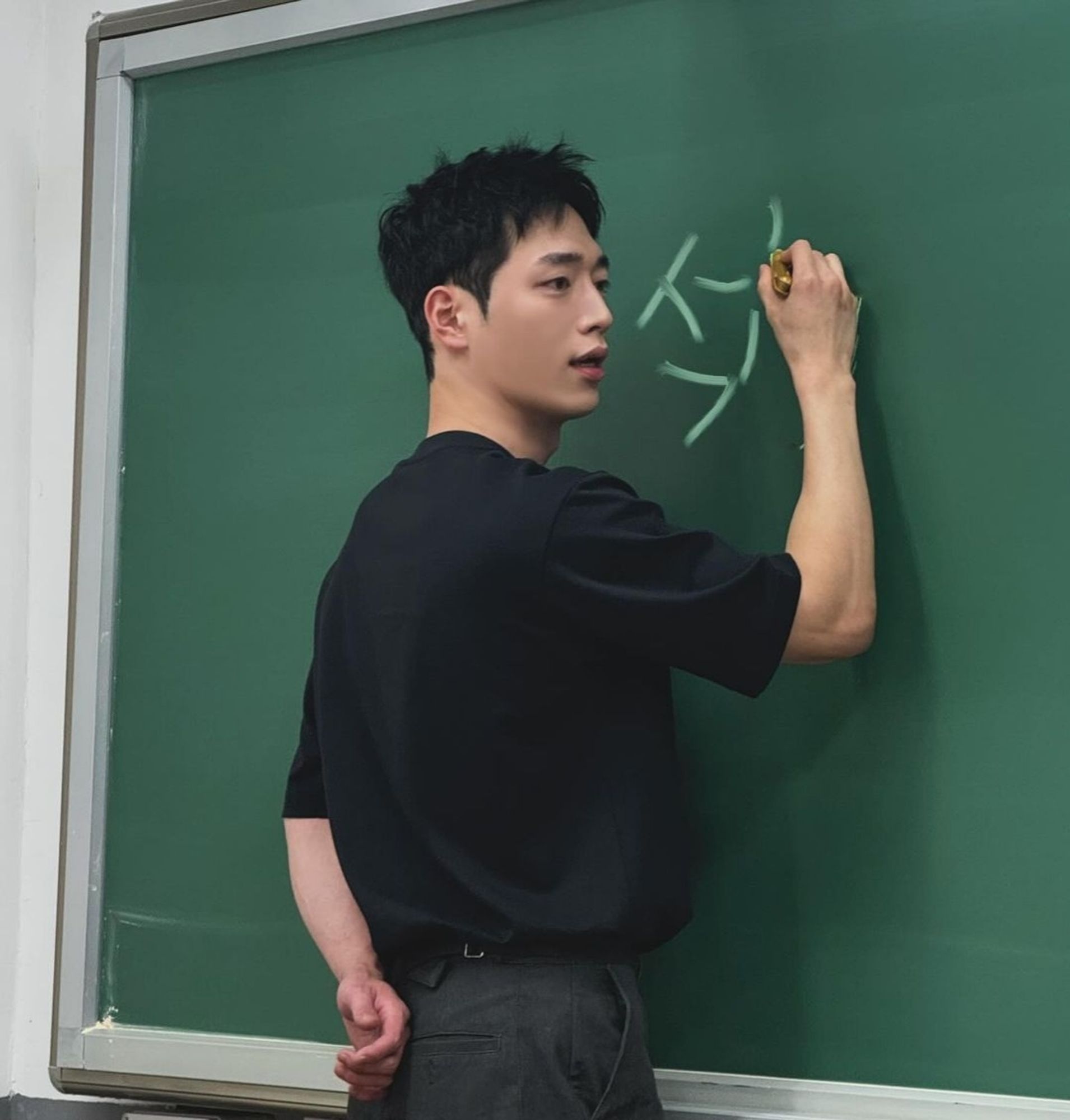 Ator Seo Kang Joon escrevendo na lousa, "seok"