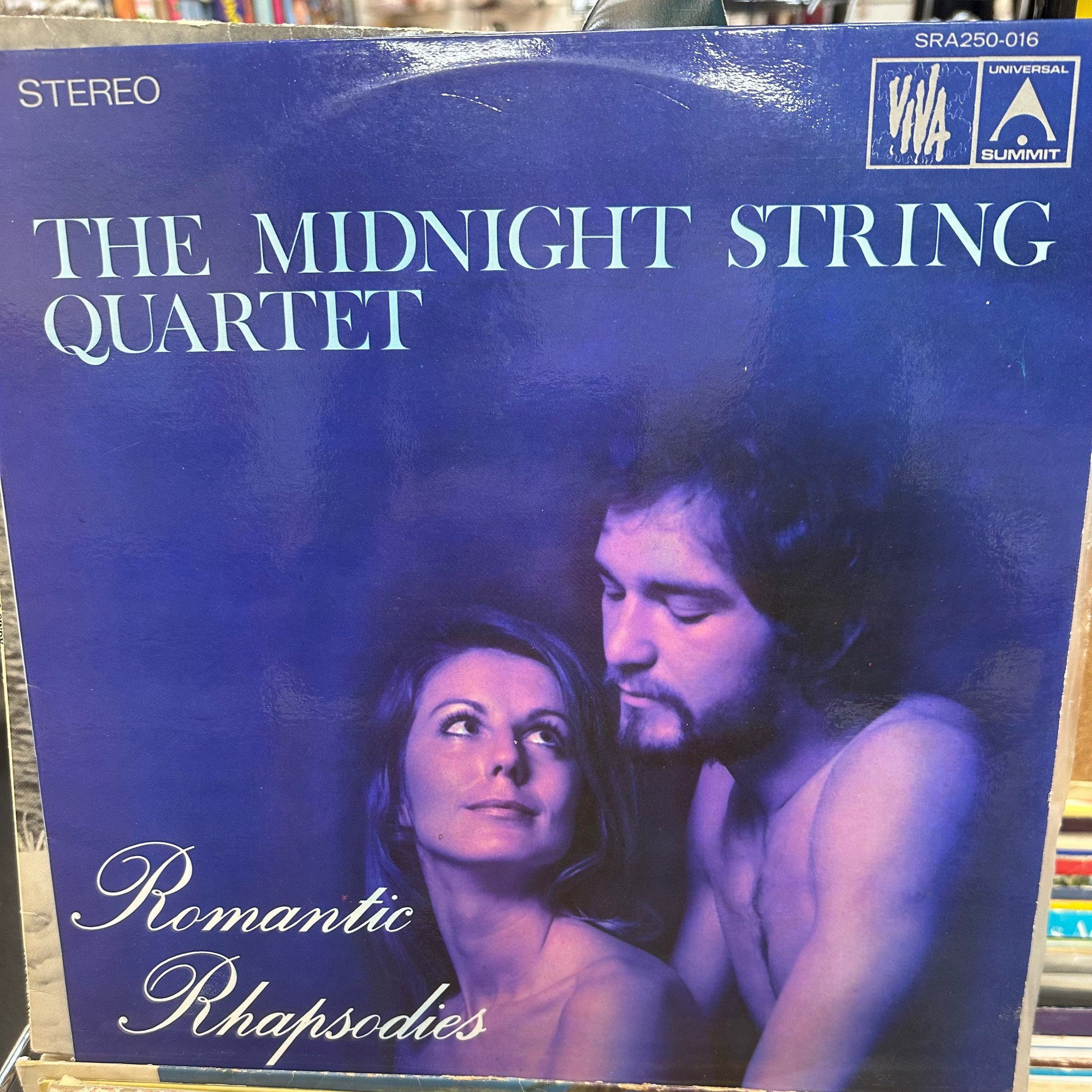 The front cover of a vinyl album by The Midnight String Quartet entitled “Romantic Rhapsodies” in which the gentleman appears to be, um, well, not getting her pregnant from that position.