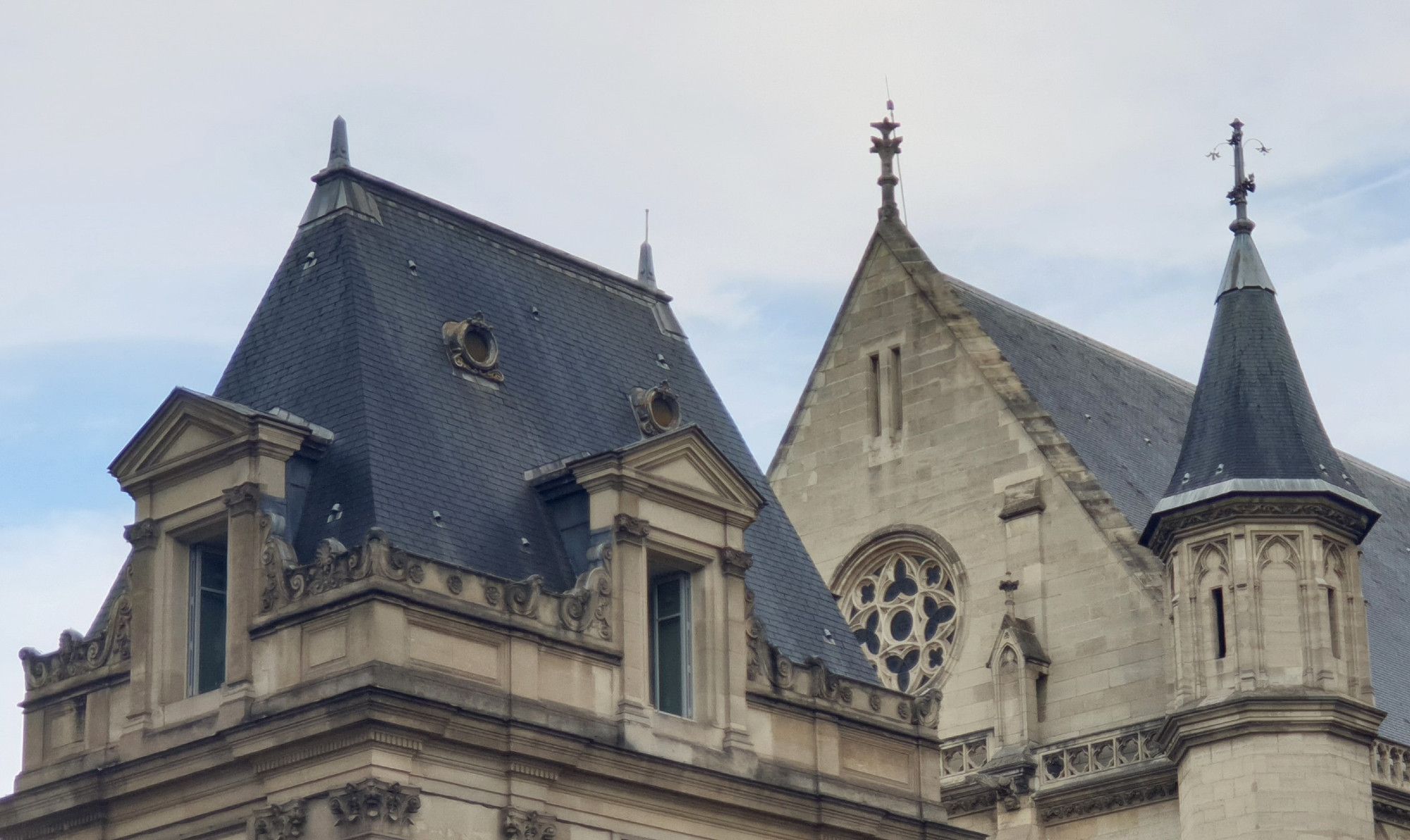 Toiture parisienne - église avec la rosace et une tourelle sur la droite. Ciel couvert