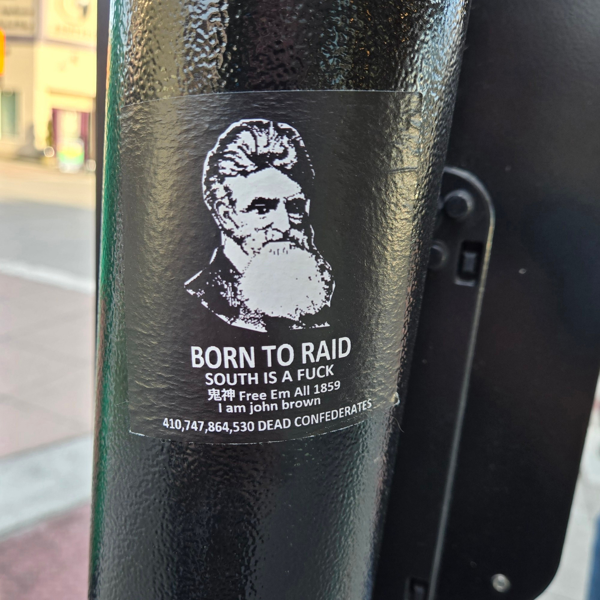 A sticker on a crosswalk light in Renton, WA

A black and white drawing of John Brown with text below:

BORN TO RAID
SOUTH IS A FUCK
Free Em All 1859
I am john brown
410,747,864,530 DEAD CONFEDERATES