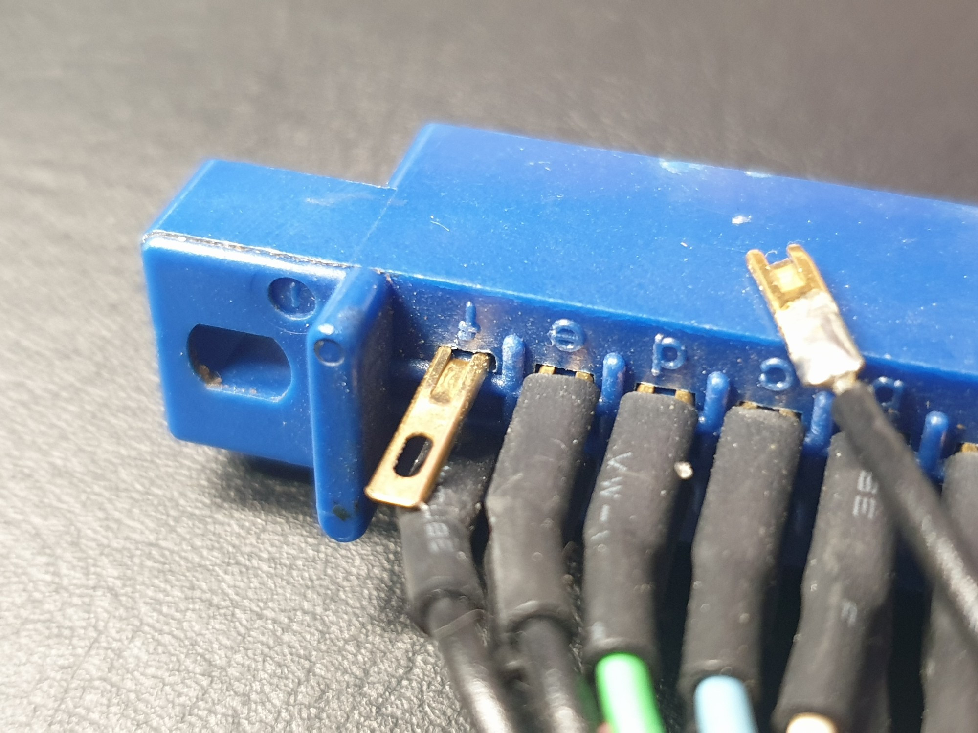 Close up of a connector with soldered wires, and a new unconnected pin. A wire is bwarvy with a snapped pin. Exits are north and Stephen. 