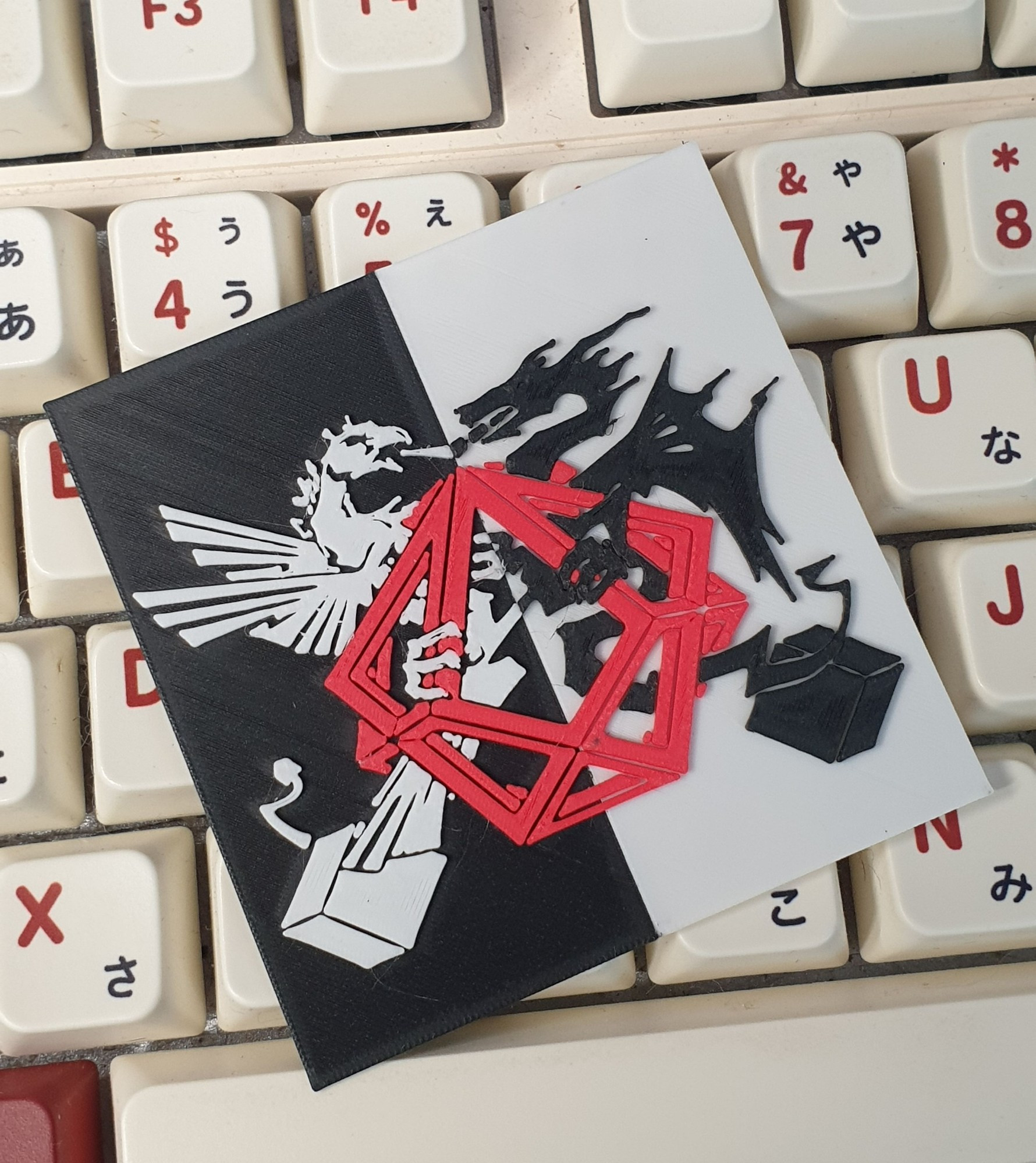 A 3D print of the cover of the classic Atari 800 game Archon, featuring a phoenix and dragon locked in combat over a double cube. 