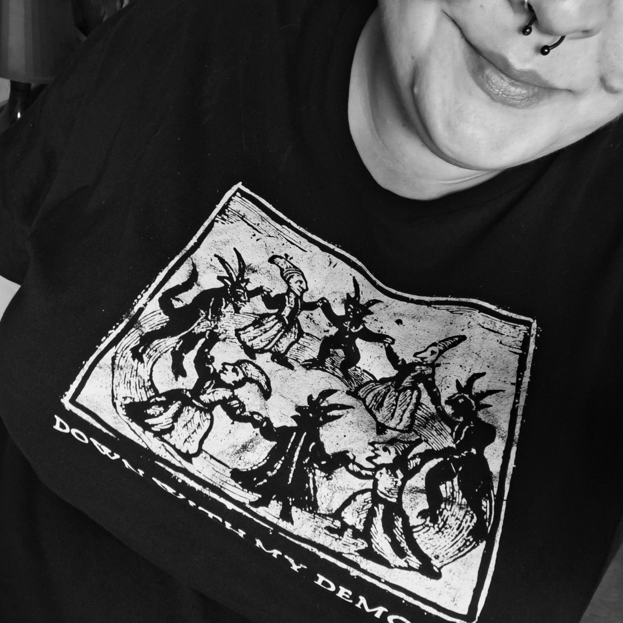 Schwarzweiß Selfie,Gesicht ist halb zu sehen. Trage ein Shirt,darauf ein alter Druck auf dem Leute mit Dämonen tanzen Schriftzug: down with my demons.