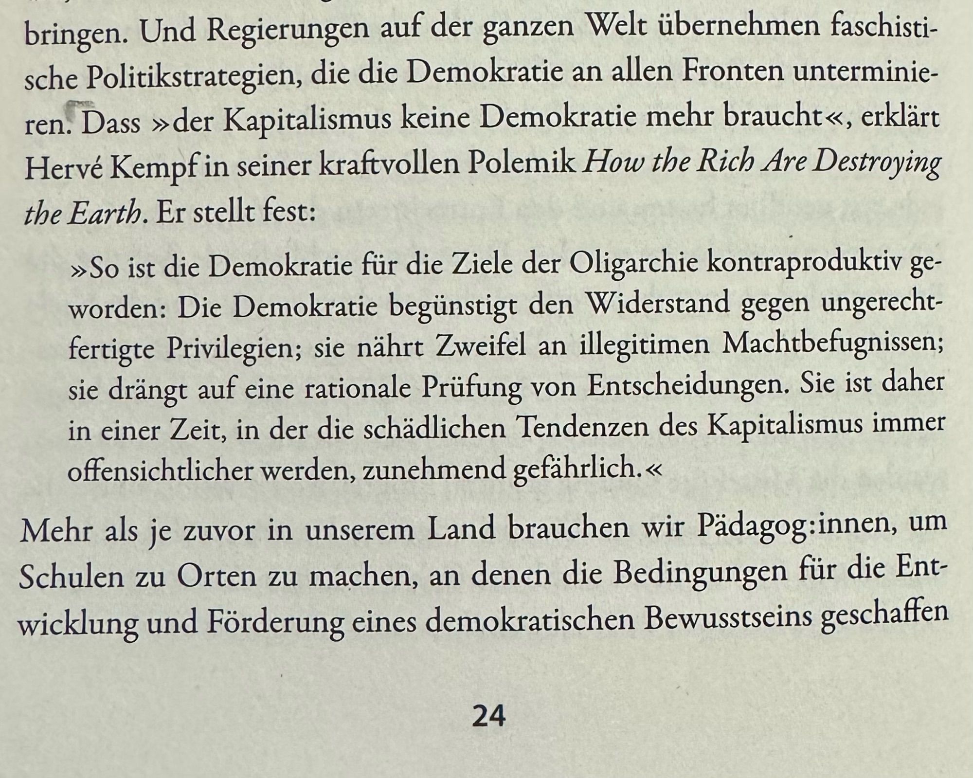 Man sieht ein Foto der Buchseite 24 mit folgenden Text: bringen. Und Regierungen auf der ganzen Welt übernehmen faschistische Politikstrategien, die die Demokratie an allen Fronten unterminieren. Dass »der Kapitalismus keine Demokratie mehr braucht«, erklärt Hervé Kempf in seiner kraftvollen Polemik How the Rich Are Destroying the Earth. Er stellt fest:
»So ist die Demokratie für die Ziele der Oligarchie kontraproduktiv geworden: Die Demokratie begünstigt den Widerstand gegen ungerechtfertigte Privilegien; sie nährt Zweifel an illegitimen Machtbefugnissen; sie drängt auf eine rationale Prüfung von Entscheidungen. Sie ist daher in einer Zeit, in der die schädlichen Tendenzen des Kapitalismus immer offensichtlicher werden, zunehmend gefährlich.«
Mehr als je zuvor in unserem Land brauchen wir Pädagog:innen, um Schulen zu Orten zu machen, an denen die Bedingungen für die Entwicklung und Förderung eines demokratischen Bewusstseins geschaffen