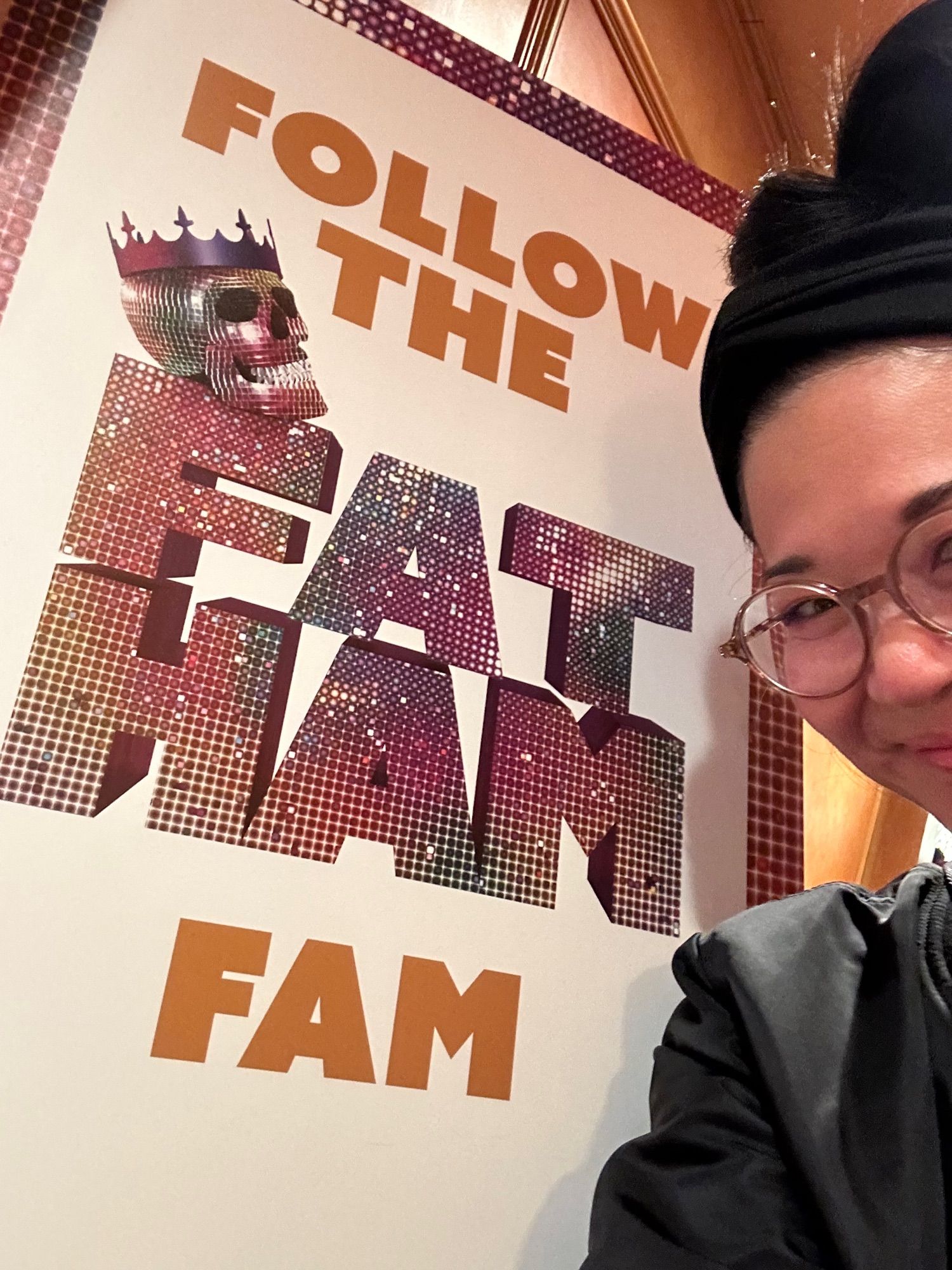 Woman next to poster for the Broadway show Fat Ham.