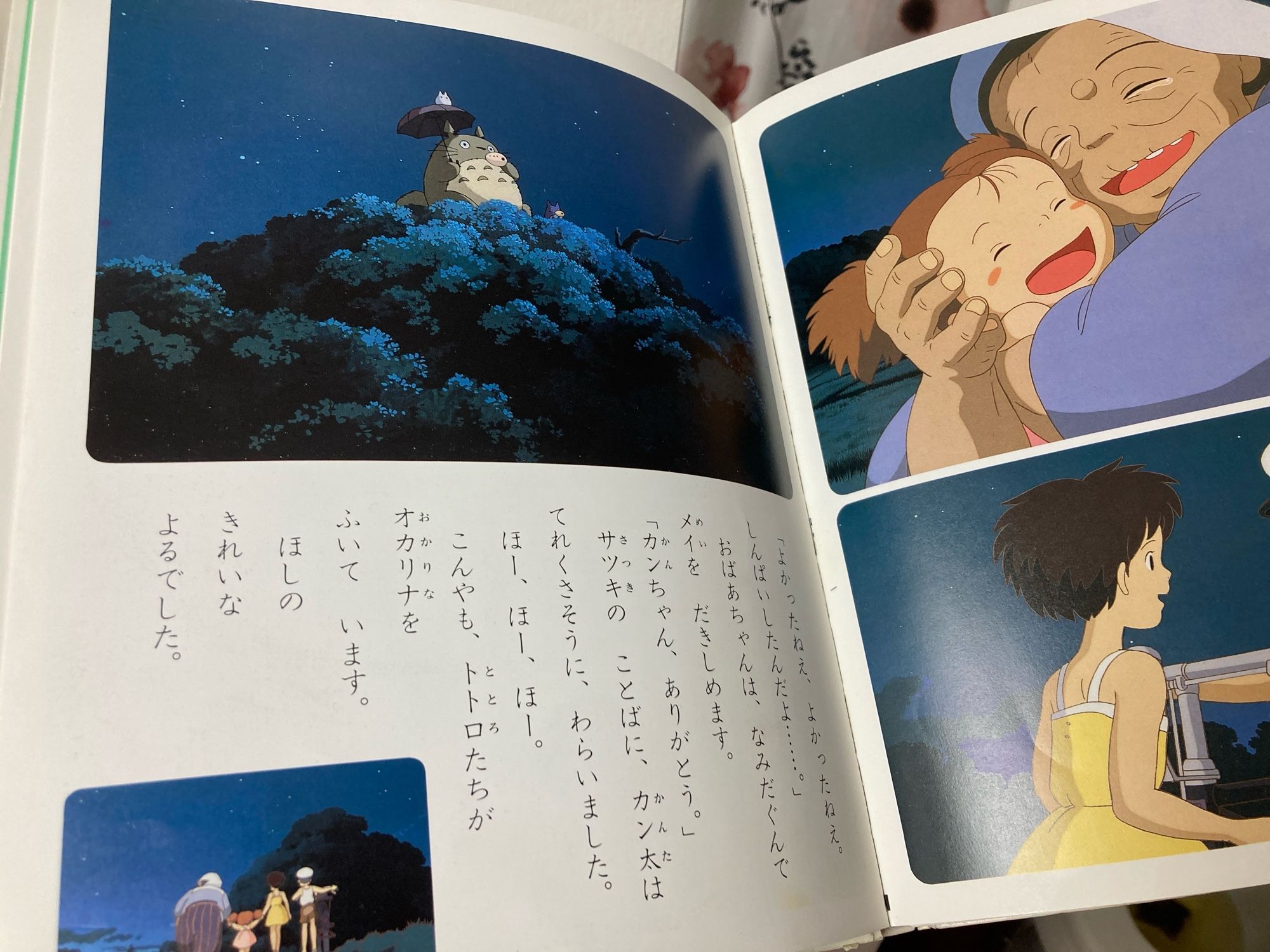 A photograph of the final pages of the story, with scenes taken from the movie of Kanta's grandmother embracing Mei, Satsuki thanking Kanta, the Totoro family on the Camphor treetop playing ocarinas, and finally, the four humans walking down the road side by side.