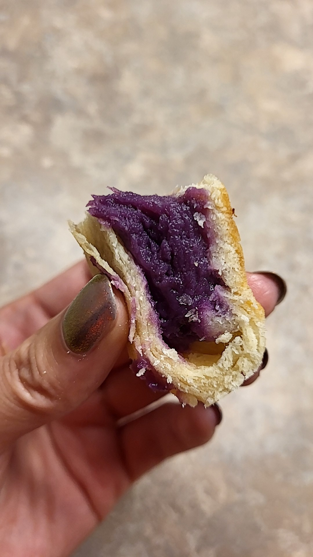 Close up of a piece of mooncake filled with ube