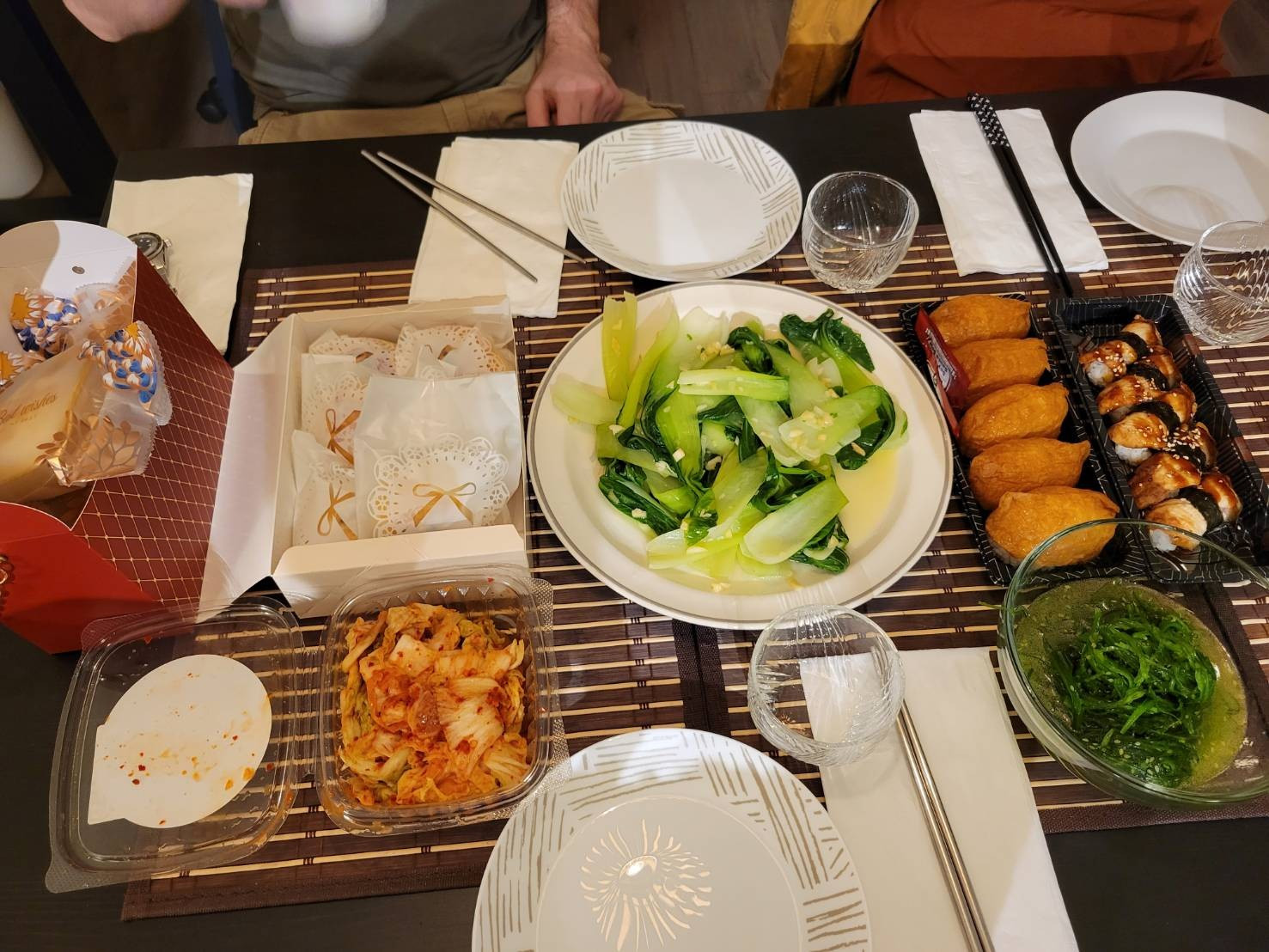 Dinner spread - Box of individually wrapped mooncakes, side of kimchi, vegetable dish, sushi and seaweed salad