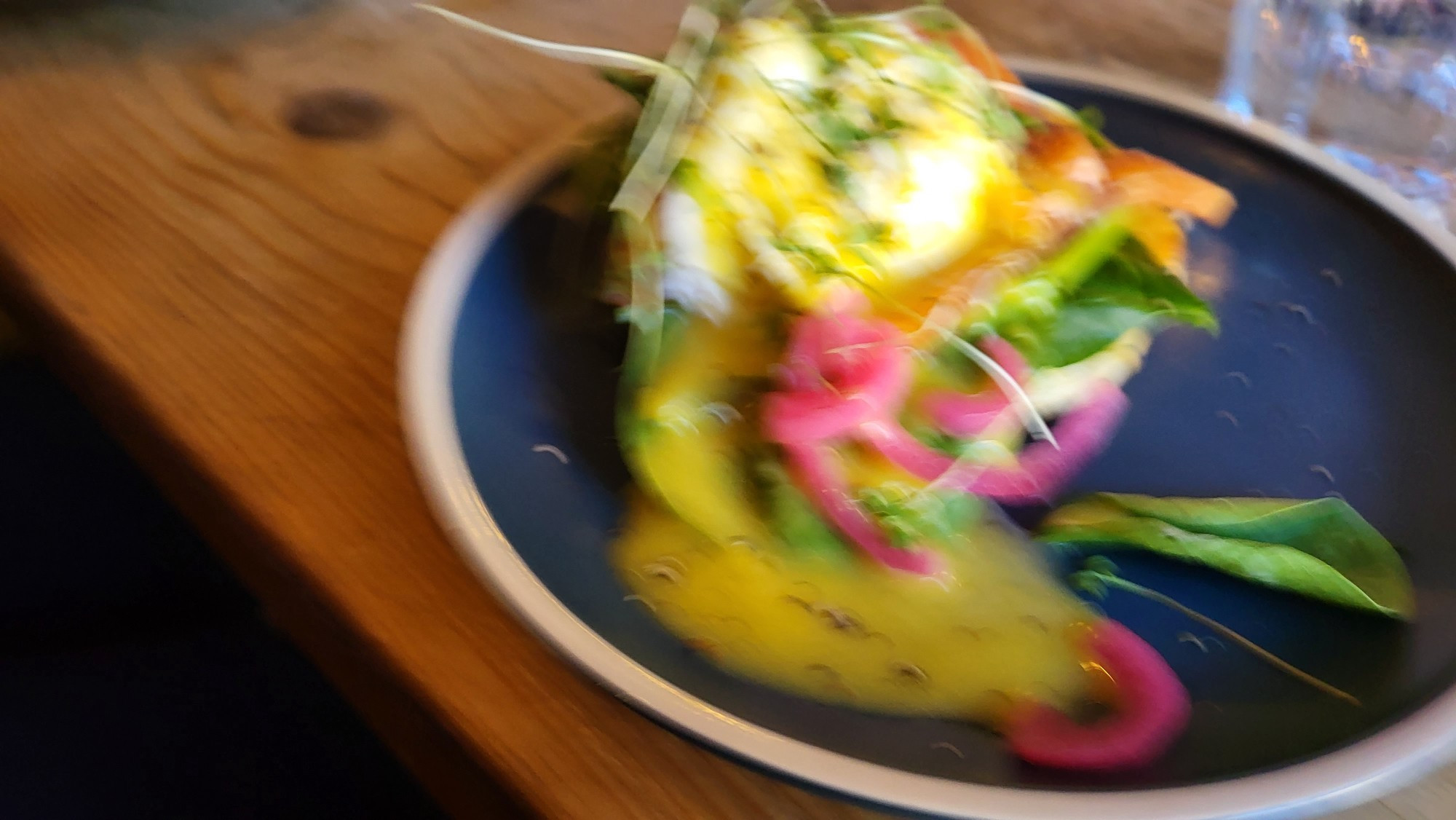 Blurry picture of brunch dish with a poached egg on toast and some greens?