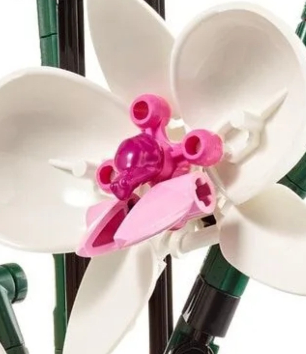 Close up of Lego orchid with a hot pink frog piece in the floret