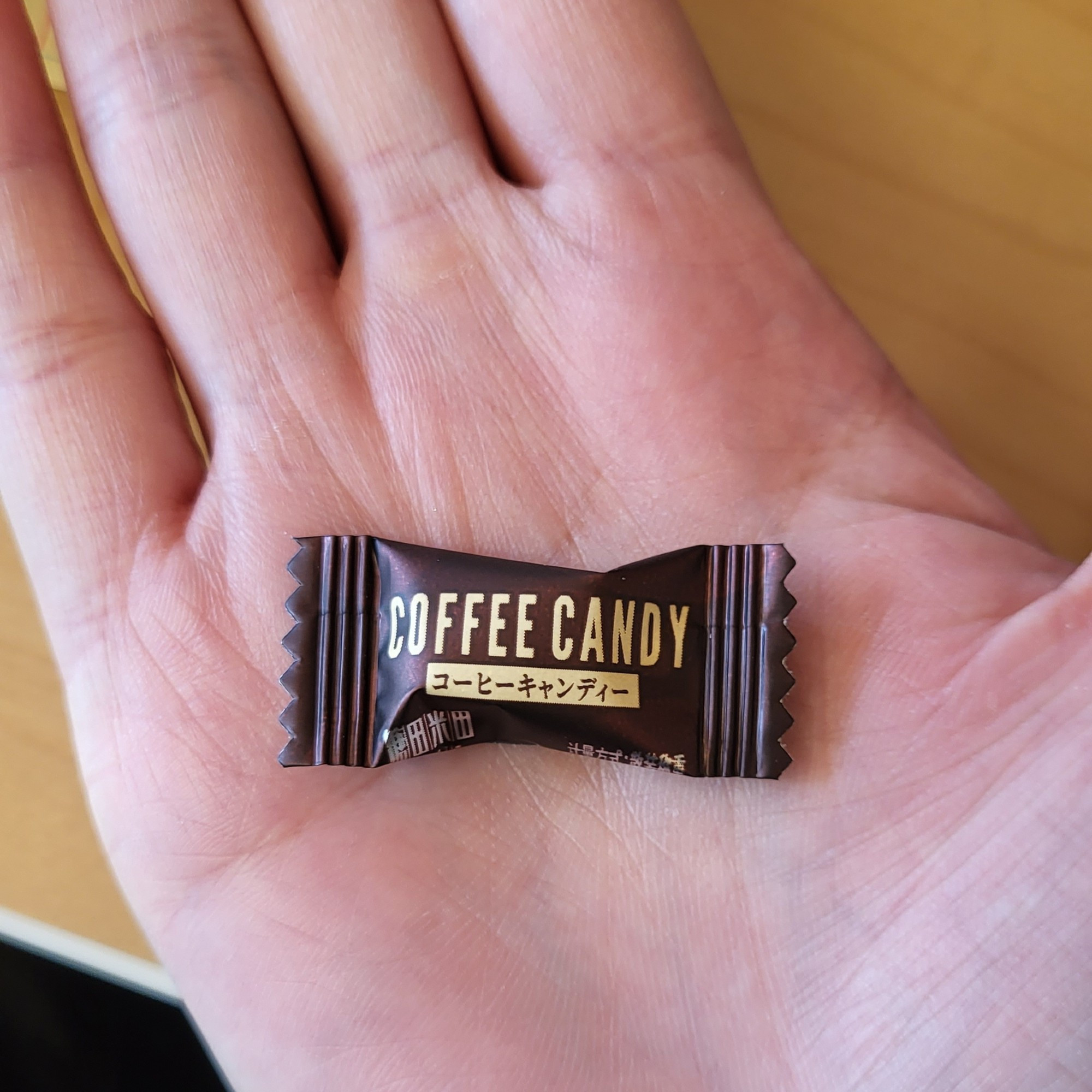 Small coffee candy in wrapper on my palm