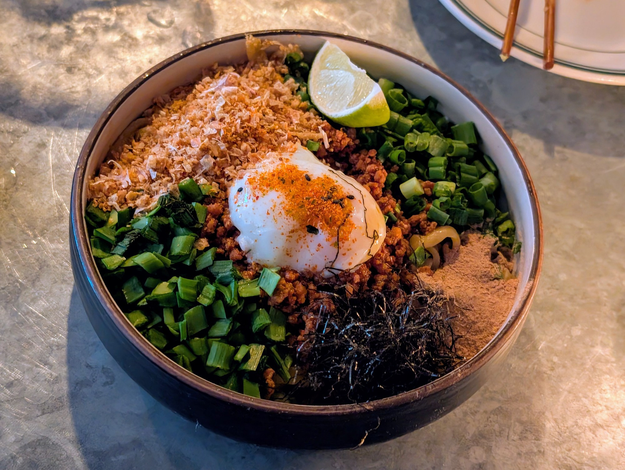 Bowl of mazemen noodles with toppings.