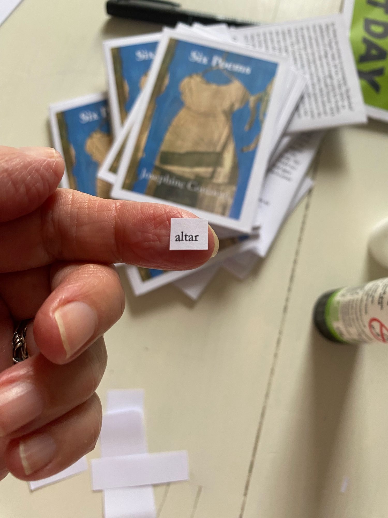 My finger holding on its tip the typed word ‘altar’, in the background, a pile of my zines.