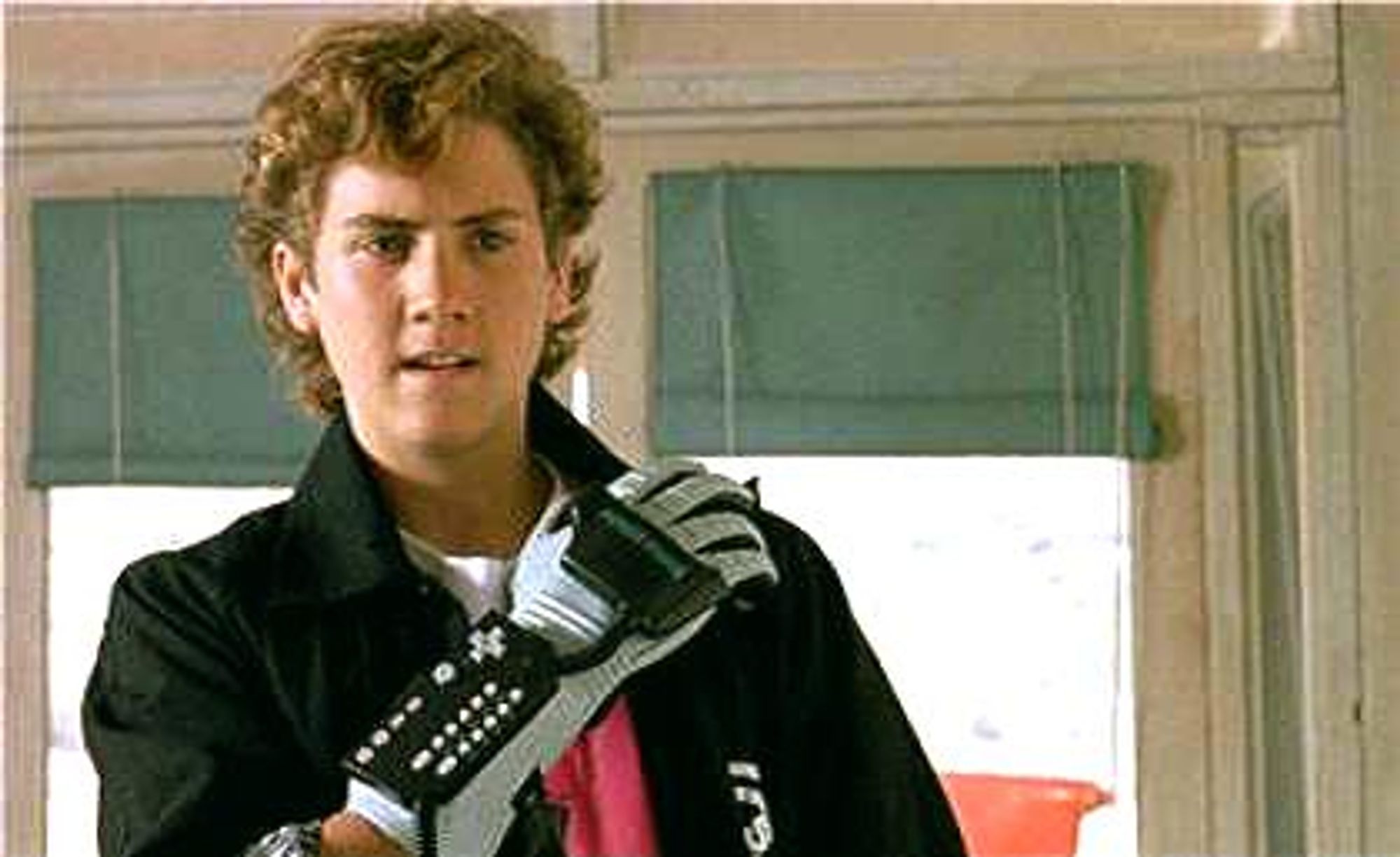 Image from the movie "The Wizard," a teenager is wearing the Nintendo Powerglove, holding it across his chest, a proud, aggressive look on his face