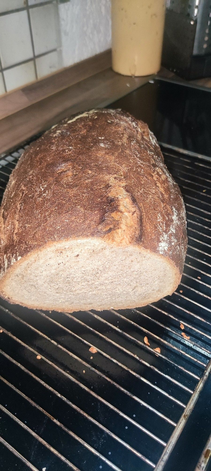 Aufgeschnittenes Brot auf einem Rost.
Schöne Maserung und knackig aussehende Kruste.