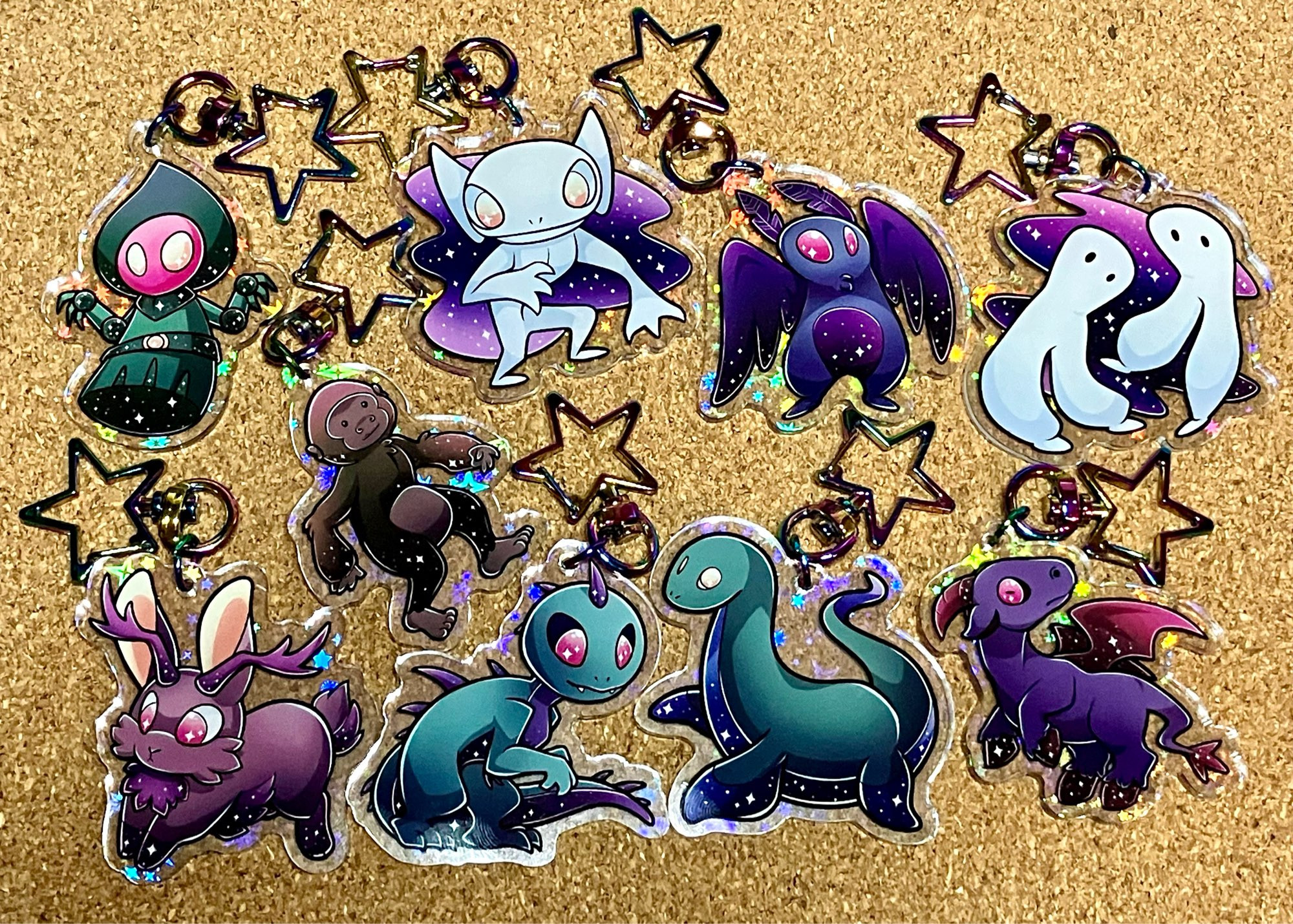 Holographic acrylic cryptid charms.