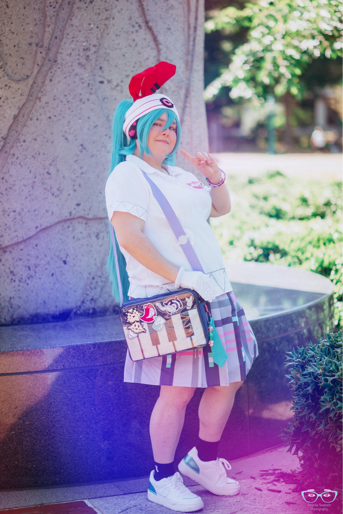 A photo of my Psychic Miku cosplay, in a pose showing the piano bag accessory.