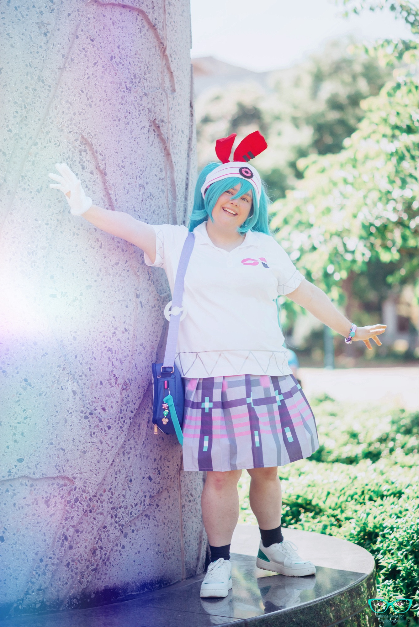 A full body shot posed next to a stone pillar with arms outstretched.