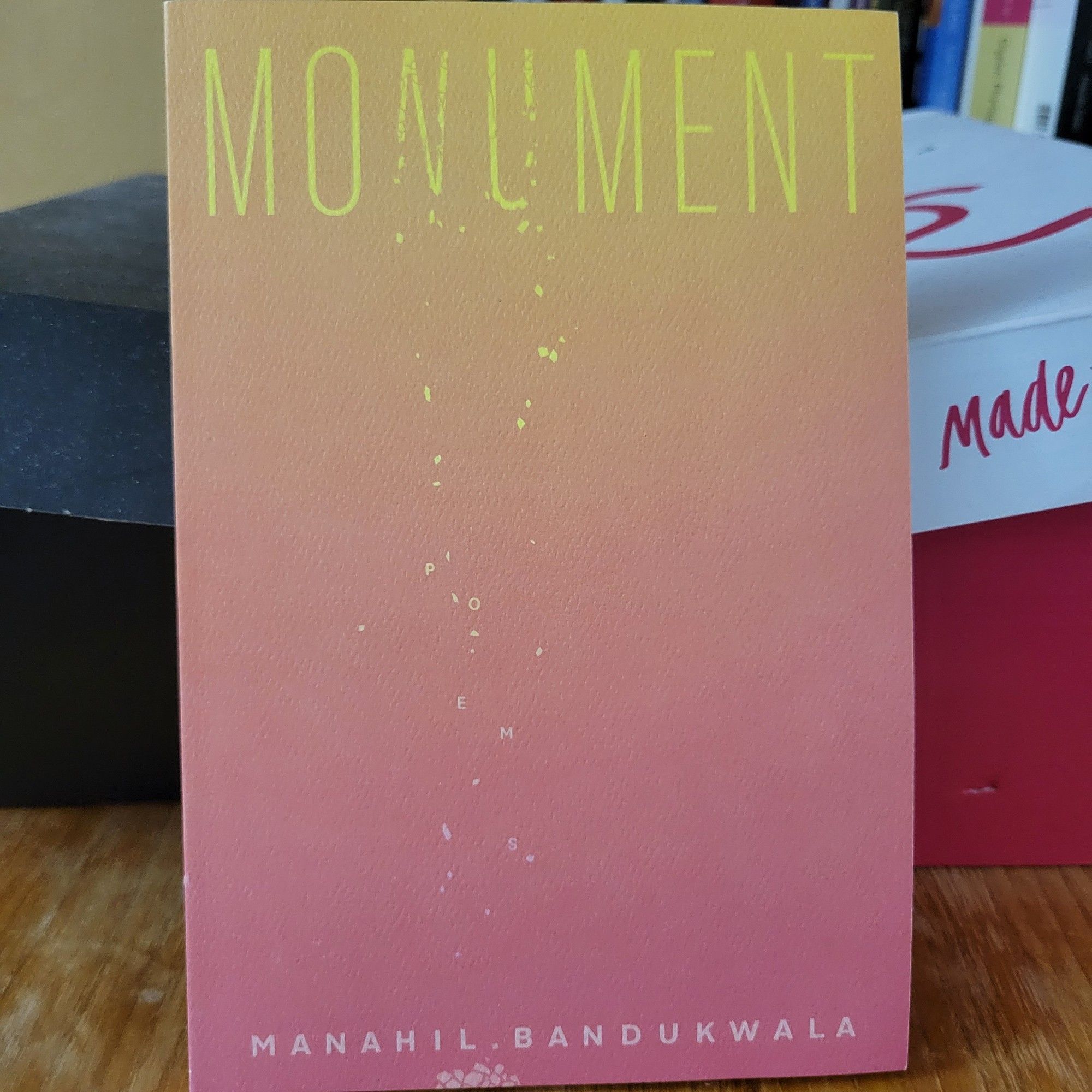 Orange cover with the word M O N U M E N T in yellow at the top, letters falling from the N U. at the bottom, text: M A N A H I L .  B A N D U K W A L A