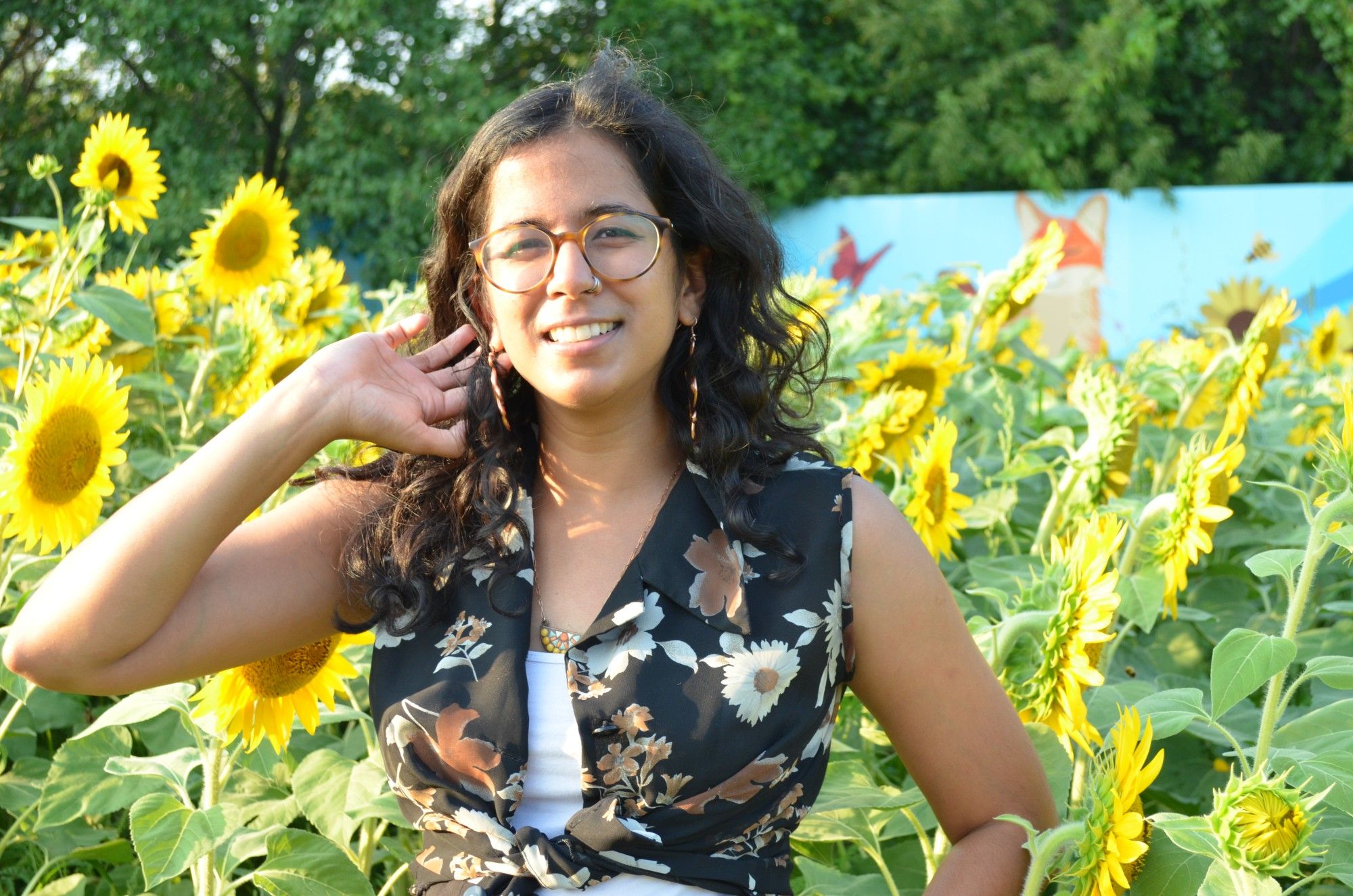 woman standing in front of sunflowers