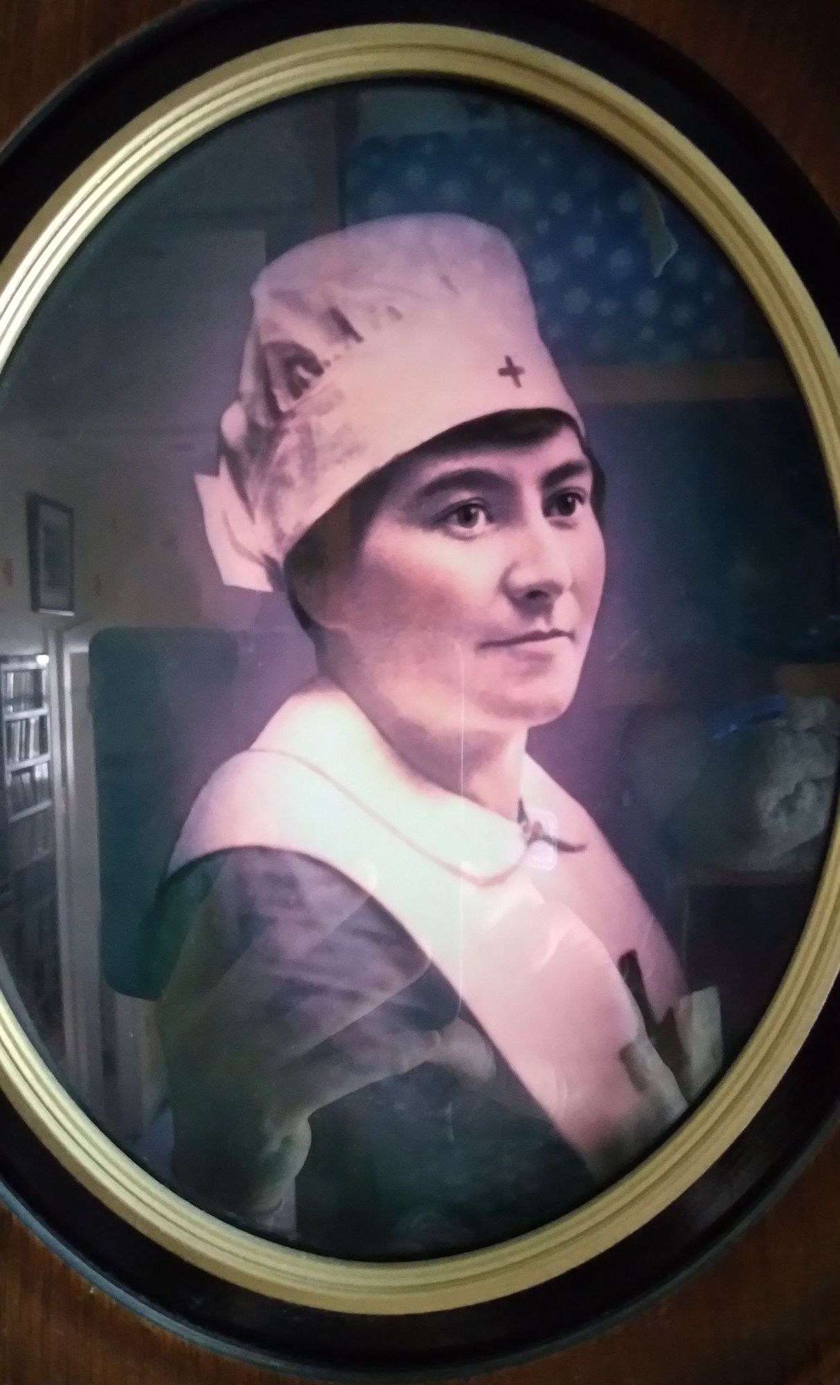 New Zealand woman Annie Leahy volunteered with the New Zealand War Contingent Association and worked at the NZ Hospital at Walton-on-Thames.
Large oval portait photo of kind looking womaan with white nurses cap and apron with small red crosses.