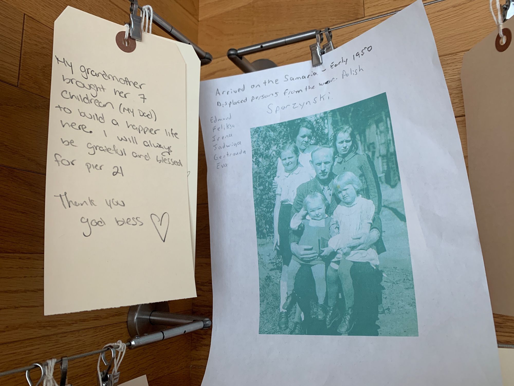 Messages from immigrants who arrived in Canada via Pier 21. On the left: “My grandmother brought her 7 children (my Dad) to build a happier life here. I will always be grateful and blessed for Pier 21. Thank you God bless. ❤️” On the right: “Arrived on the Samaria - early 1950. Displaced persons from the war. Polish. Sporzynski - Edmund, Feliksa, Irene, Jadwiga, Gertrauda, Eva” accompanied by a computer-printed photo of the family.