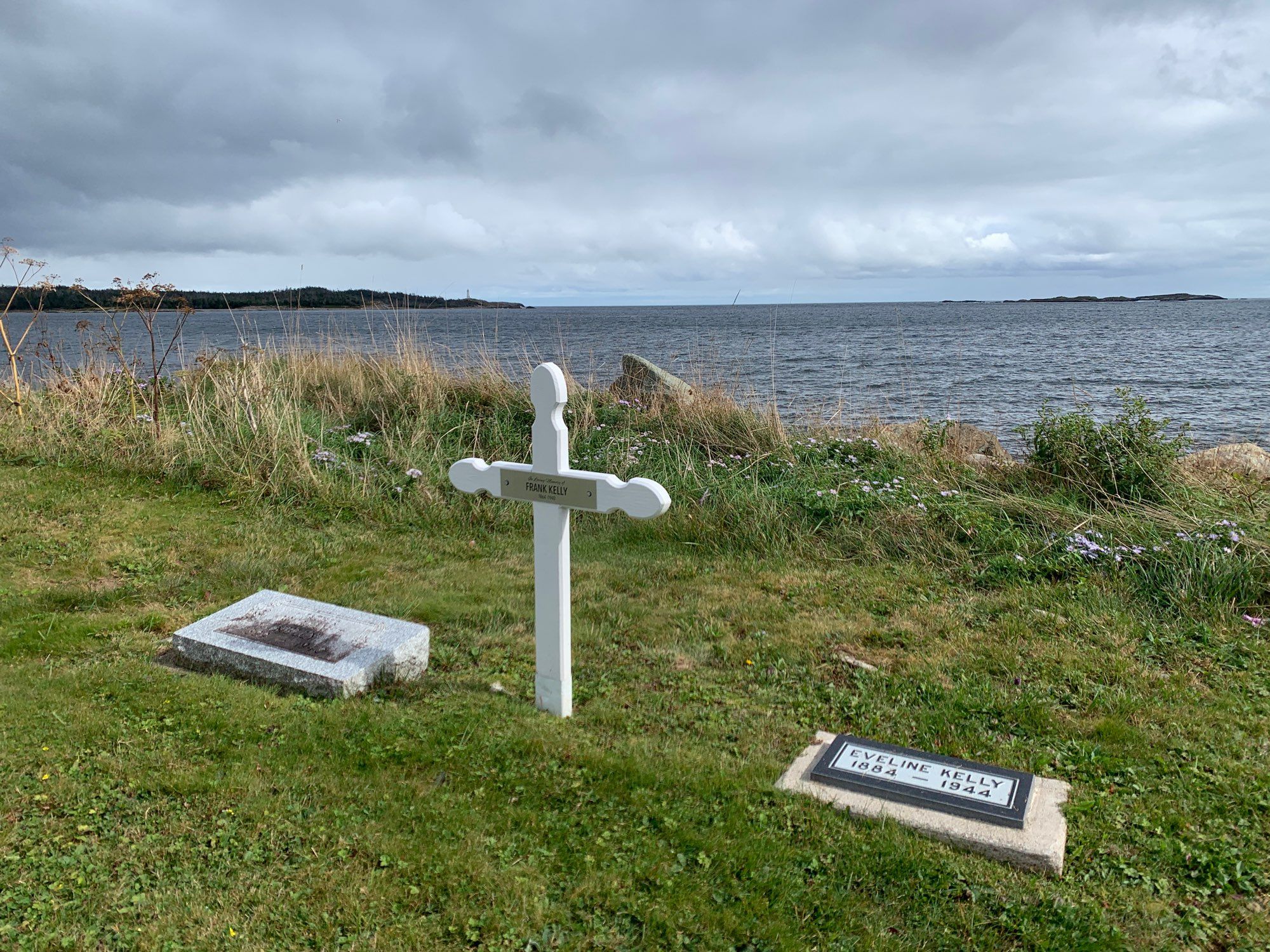 Graves in Heritage Cemetery with Louisbourg Lighthouse in the distance.