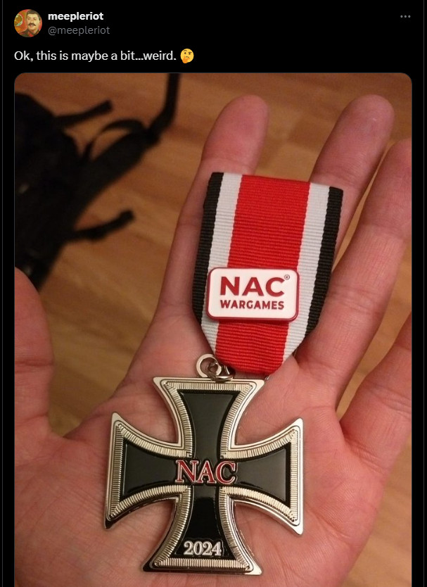 Screenshot of Tweet from meepleriot of an Iron Cross medal replica given out at Spiel by NAC Wargames.