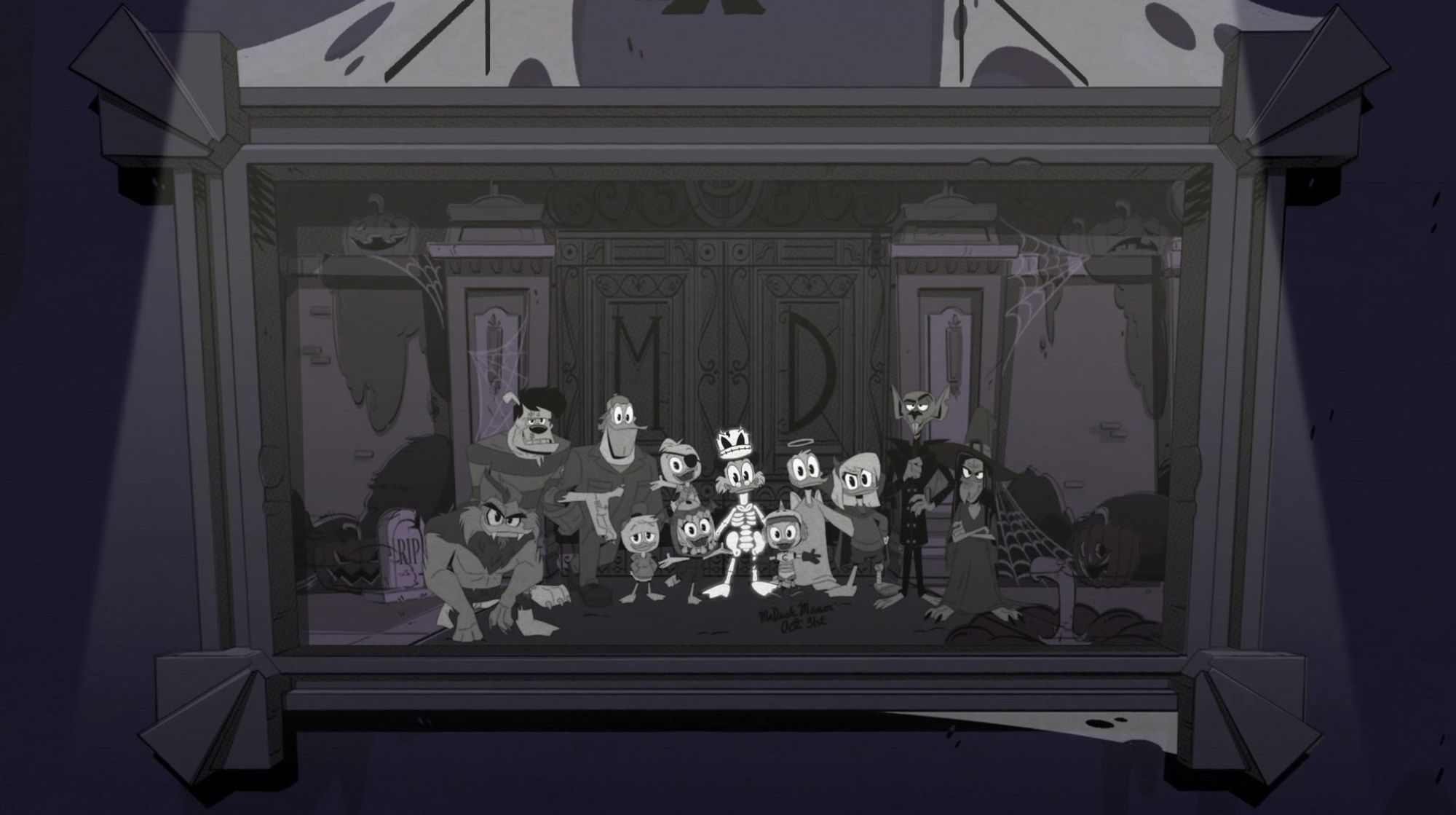 A screenshot of a framed picture with cob webs on the top from the DuckTales (2017) season 3 and Halloween special "The Trickening!" Serving as a lighthearted reference to The Shining, the picture depicts Scrooge McDuck (dressed as a skeleton), Huey Duck (dressed in a Gizmoduck costume he made himself), Dewey Duck (dressed as a pirate on vacation), Louie Duck (who is wearing Huey's red hat), Webby Vanderquack-McDuck (dressed as Balor the Evil Eye Demon King), Donald and Della Duck (dressed as an angel and a devil respectively), Launchpad McQuack (dressed as an "evil mechanic"), and the Hazel House monsters—Witch Hazel, Nosferatu, Frankenstein's monster, and the Wereduck—all taking a group photo together in front of the McDuck Manor gates.