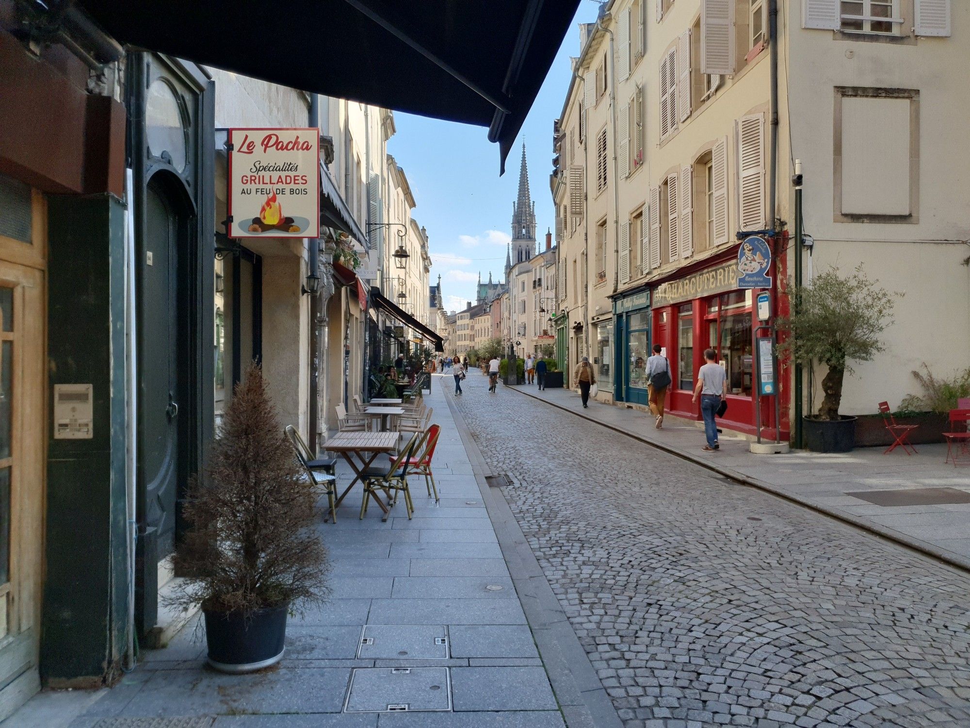 Blick in die Grande Rue in Nancy vom nordwestlichen Ende der Straße nach Südosten unter halb der aufgespannten Markise des türkischen Restaurants Le Pacha Mitte September 2024. Im Hintergrund ist der Turm der Basilika Saint-Epvre zu erkennen.