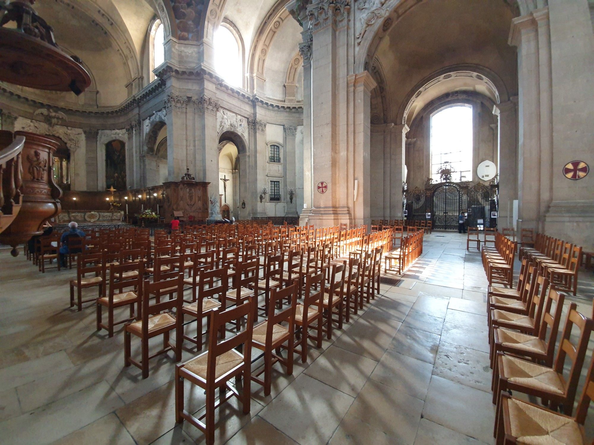 Innenansicht der Cathédrale Notre-Dame-de-l’Annonciation de Nancy Mitte September 2024. Zu sehen ist die Bestuhlung in der Mitte des Kirchenschiffs, die durch das einfallende Sonnenlicht Schatten auf den Boden wirft.