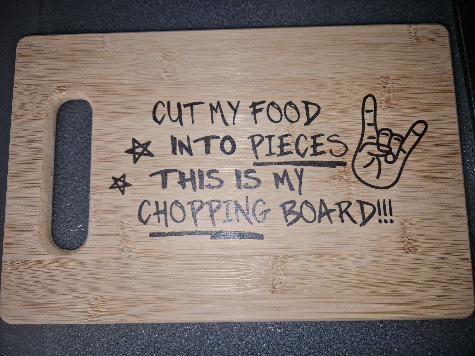 Ein Holzbrett mit Aufdruck "Cut my food into pieces this is my chopping board!!!"