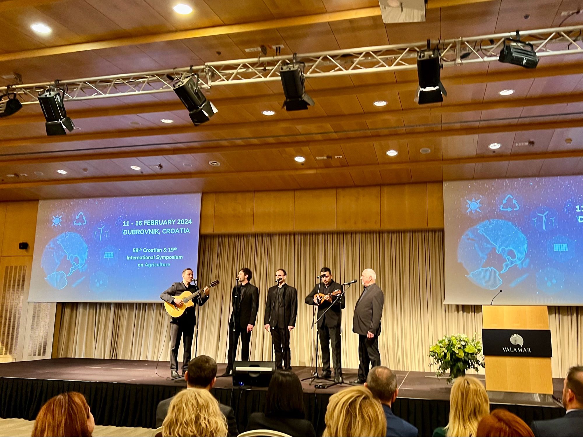 Music group with instruments sung onstage at a science symposium.