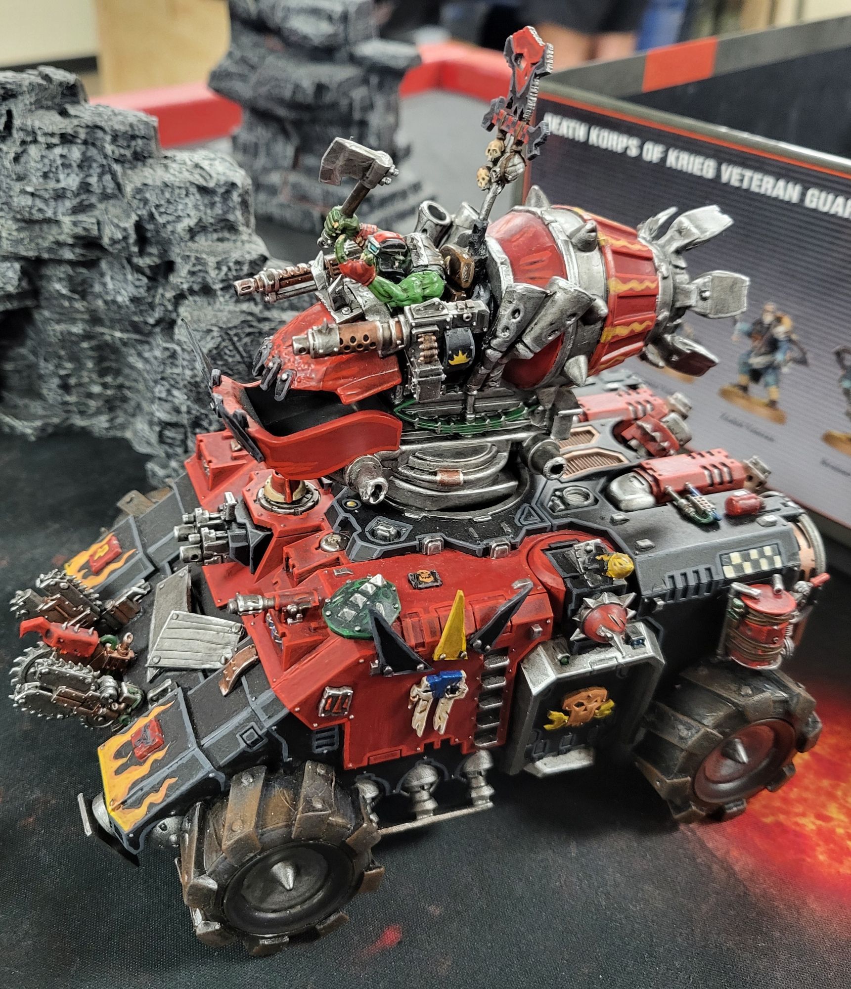 Da Repulsork. A red and black Primaris Repulsor tank with the repulsor plates replaced with giant tires. The hull is covered in bitz from ork kits. The turret is a Skylanders toy with an ork pilot.