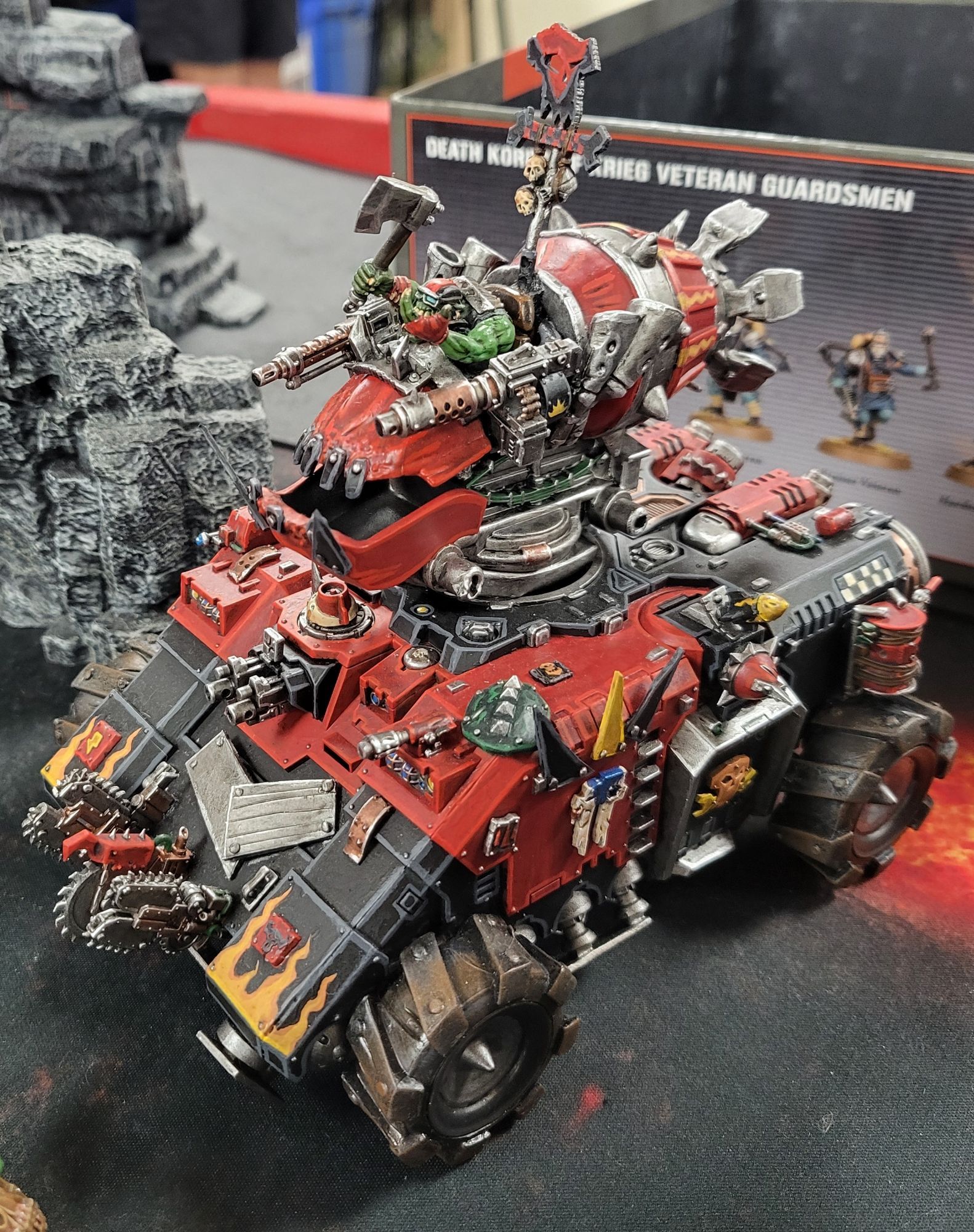 Da Repulsork. A red and black Primaris Repulsor tank with the repulsor plates replaced with giant tires. The hull is covered in bitz from ork kits. The turret is a Skylanders toy with an ork pilot.