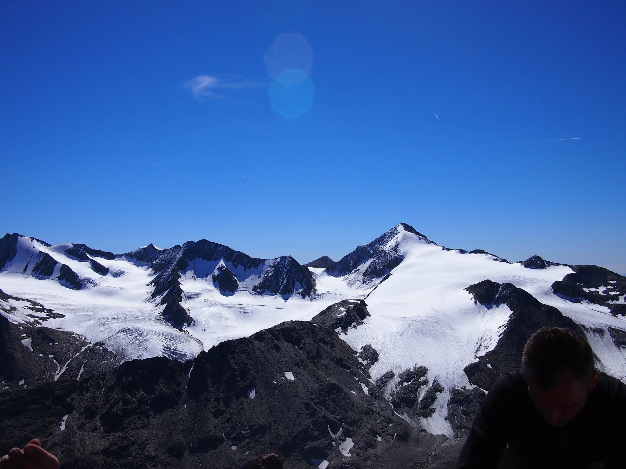 Spotless blue sky and a pretty big collection of glacier and dark rocks peaking out of them