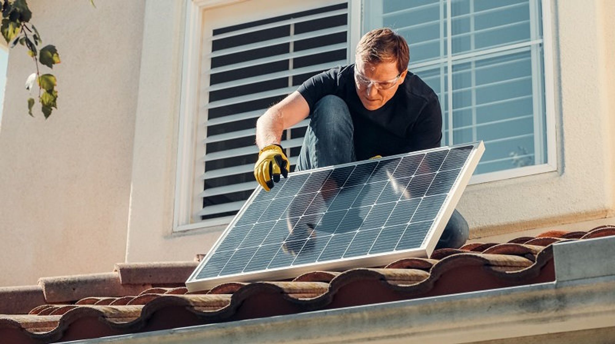 Bildbeschreibung: Jemand der eine Solarzelle an einem Dach installiert.