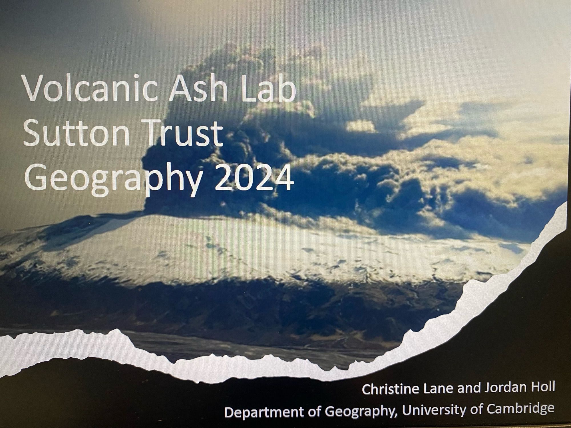 A PowerPoint slide showing an image of an erupting volcano with a plume blowing to the right, there is snow on top. The title says “Volcanic Ash Lab, Sutton Trust, Geography 2024” and authors named as Christine Lane and Jordan Holl from University of Cambridge