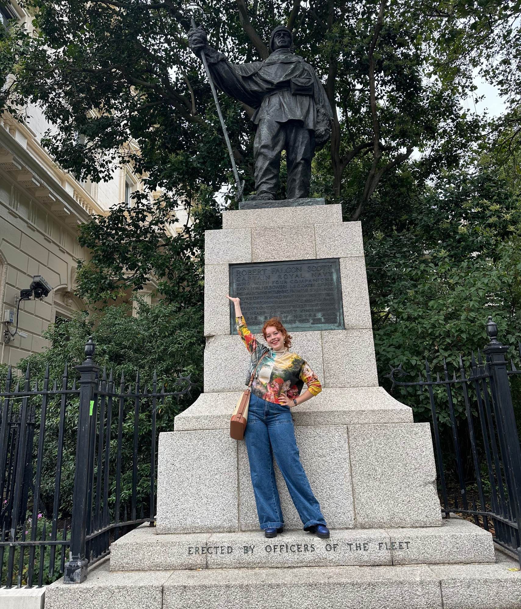 Photograph of Allegra in front of a statue of Robert Falcon Scott.