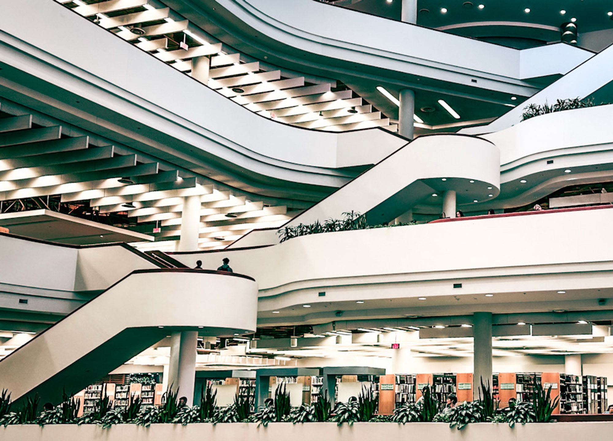 Interior of the Toronto Reference Library. Taken across the large atrium showing the white stripes of the floors  on the opposite side which run horizontally. There are also curved staircases cutting up the lines on the floors. I hope this makes sense. Very geometric. This one is taken from a different angle.