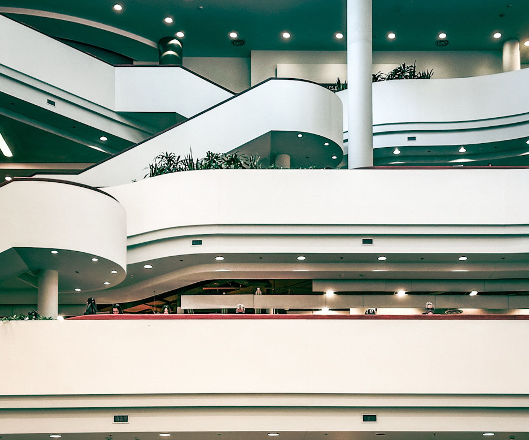 Interior of the Toronto Reference Library. Taken across the large atrium showing the white stripes of the floors  on the opposite side which run horizontally. There are also curved staircases cutting up the lines on the floors. I hope this makes sense. Very geometric.