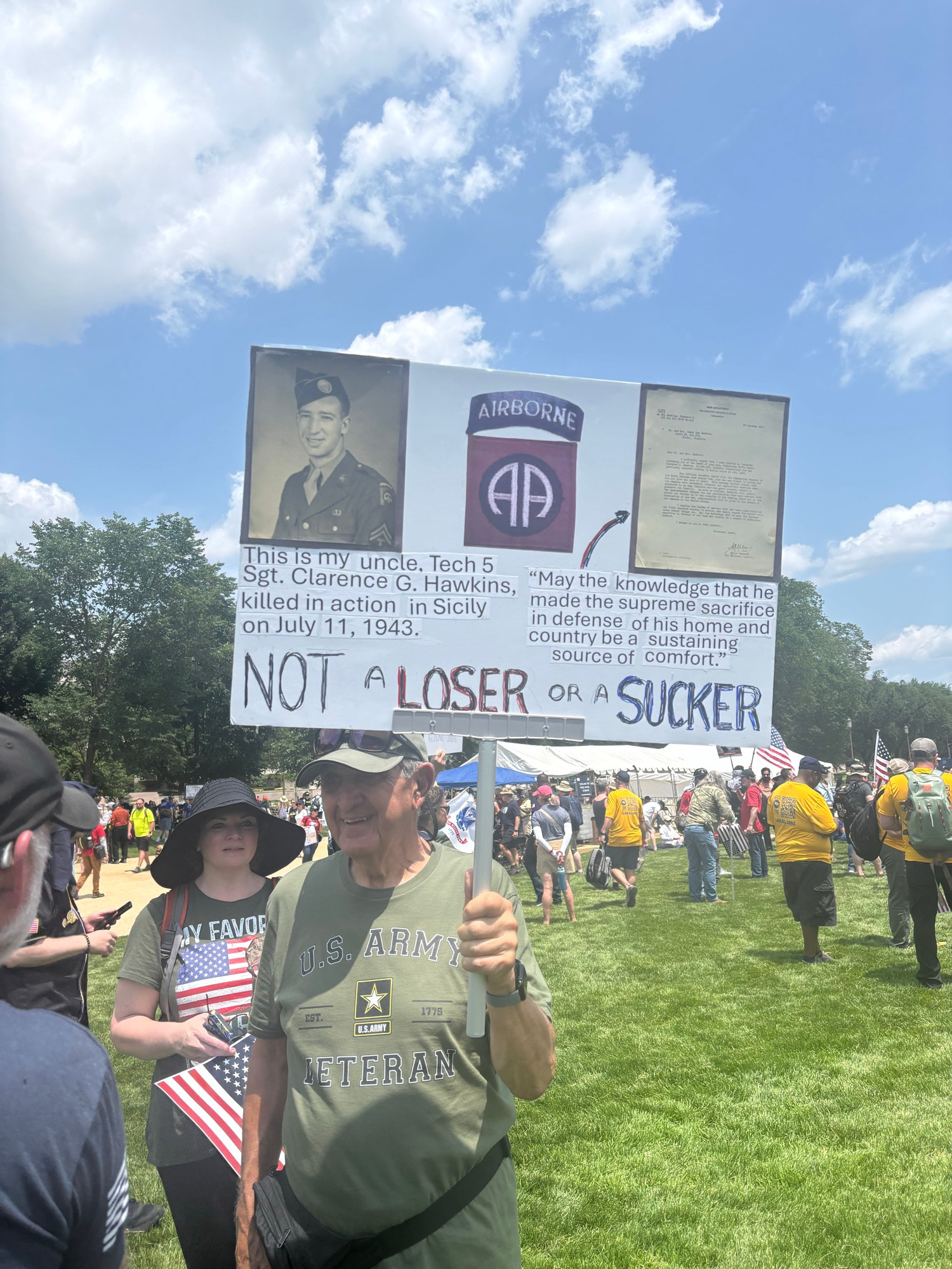 Sign held by a man in a US Army veterans T-shirt. His sign mentions his relative killed in Sicily in WWII, a picture of Eisenhower’s letter to DDay participants and not a loser of a sucker