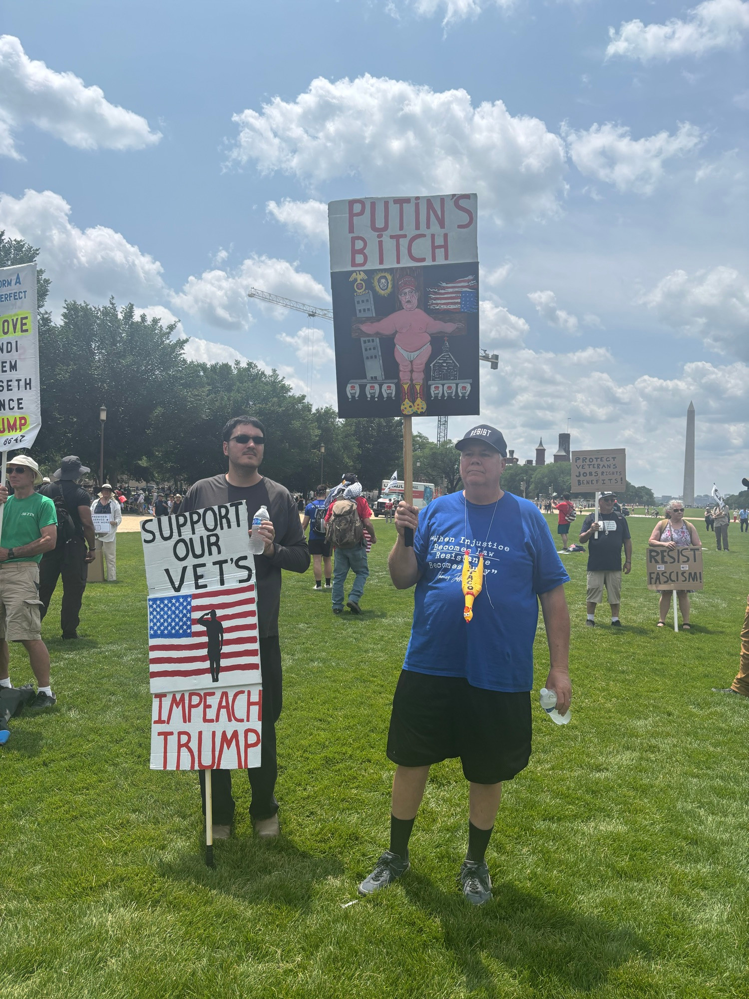 Signs . One says support our vets. Impeach Trump. The other says Putin’s bitch 