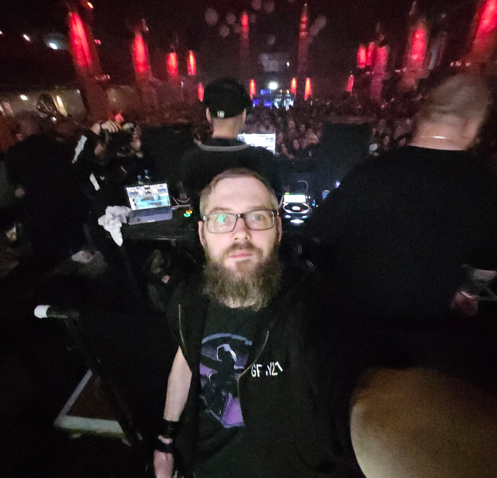 Selfie von der Bühne aus bei eine ü30 HipHop Party. Viele bunte Lichter im Hintergrund und im Vordergrund ein bärtiger Fotograf