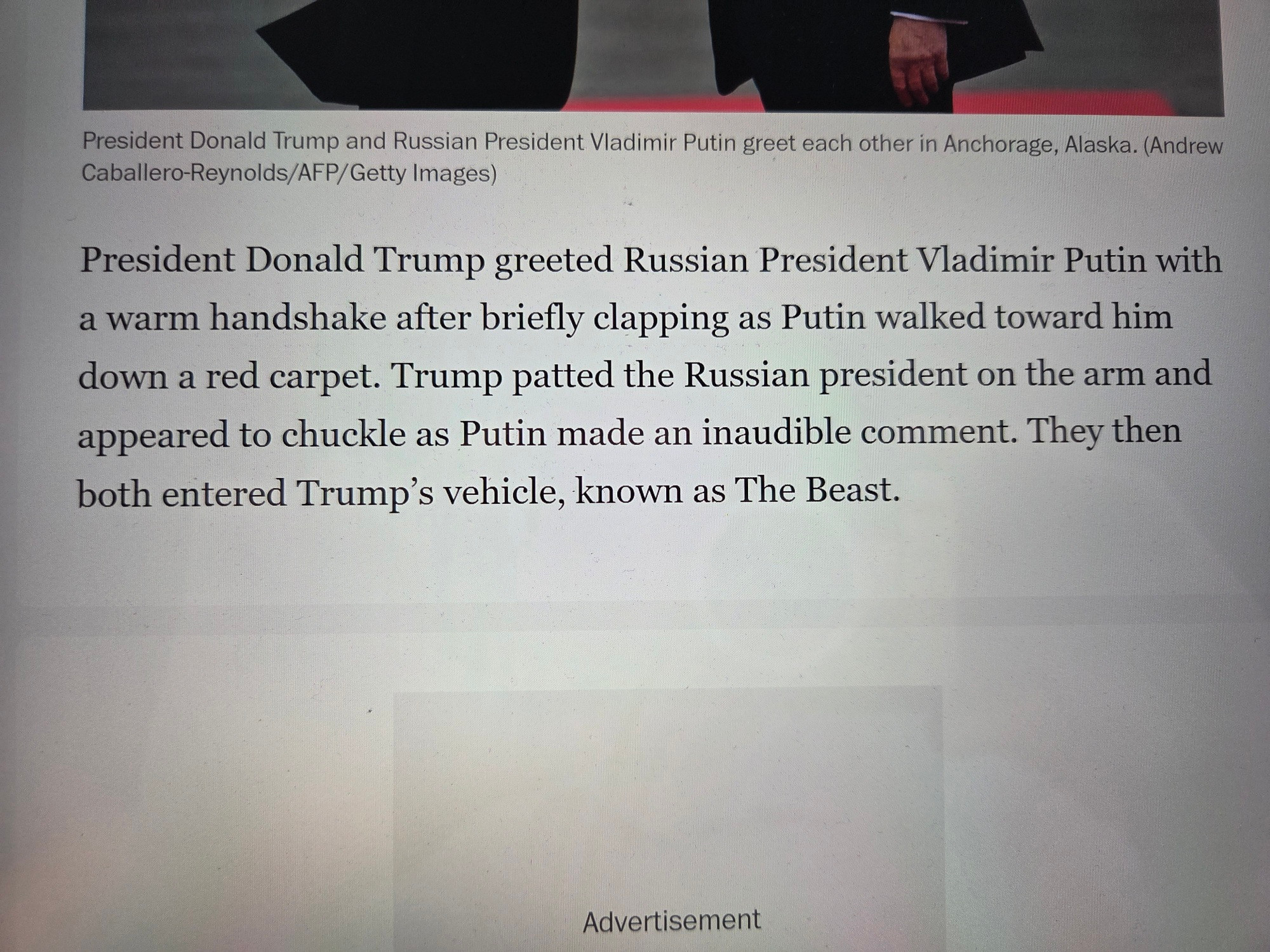 A photo of a news article on a computer. The article describes how Donald Trump fawned over Vladimir Putin upon his arrival at the Alaska summit, including by clapping for him, patting him on the arm, and "chuckling at an inaudible comment."