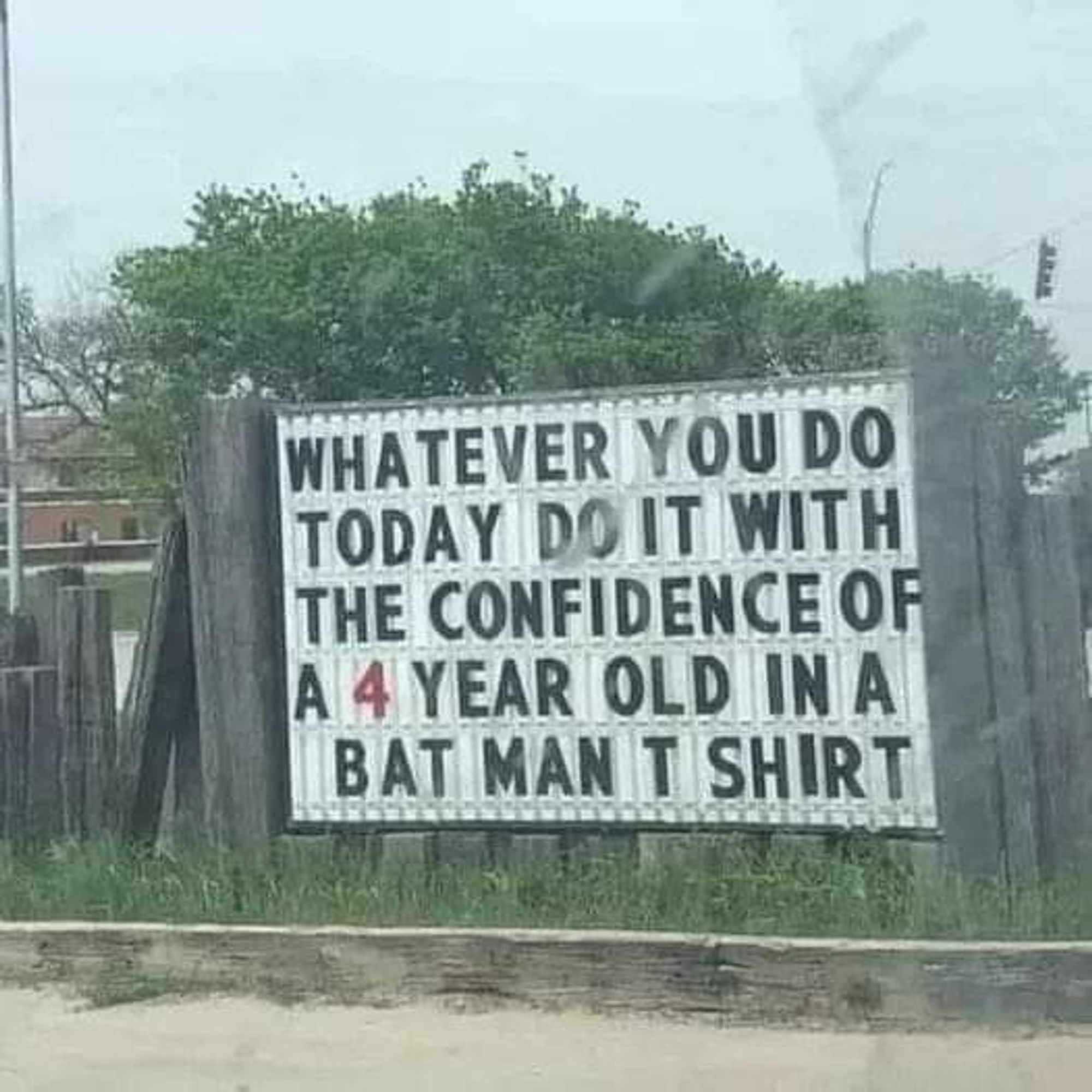 Sign on fence reads

"Whatever you do today, do it with the confidence of a 4 year old in a bat man T+ shirt"